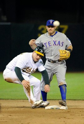 OAKLAND, CA - APRIL 29: Josh Willingham #16 of the Oakland Athletics slides into second base causing a throwing error by Ian Kinsler #5 of the Texas Rangers in the bottom of the seventh inning during a MLB game at the Oakland-Alameda County Coliseum April