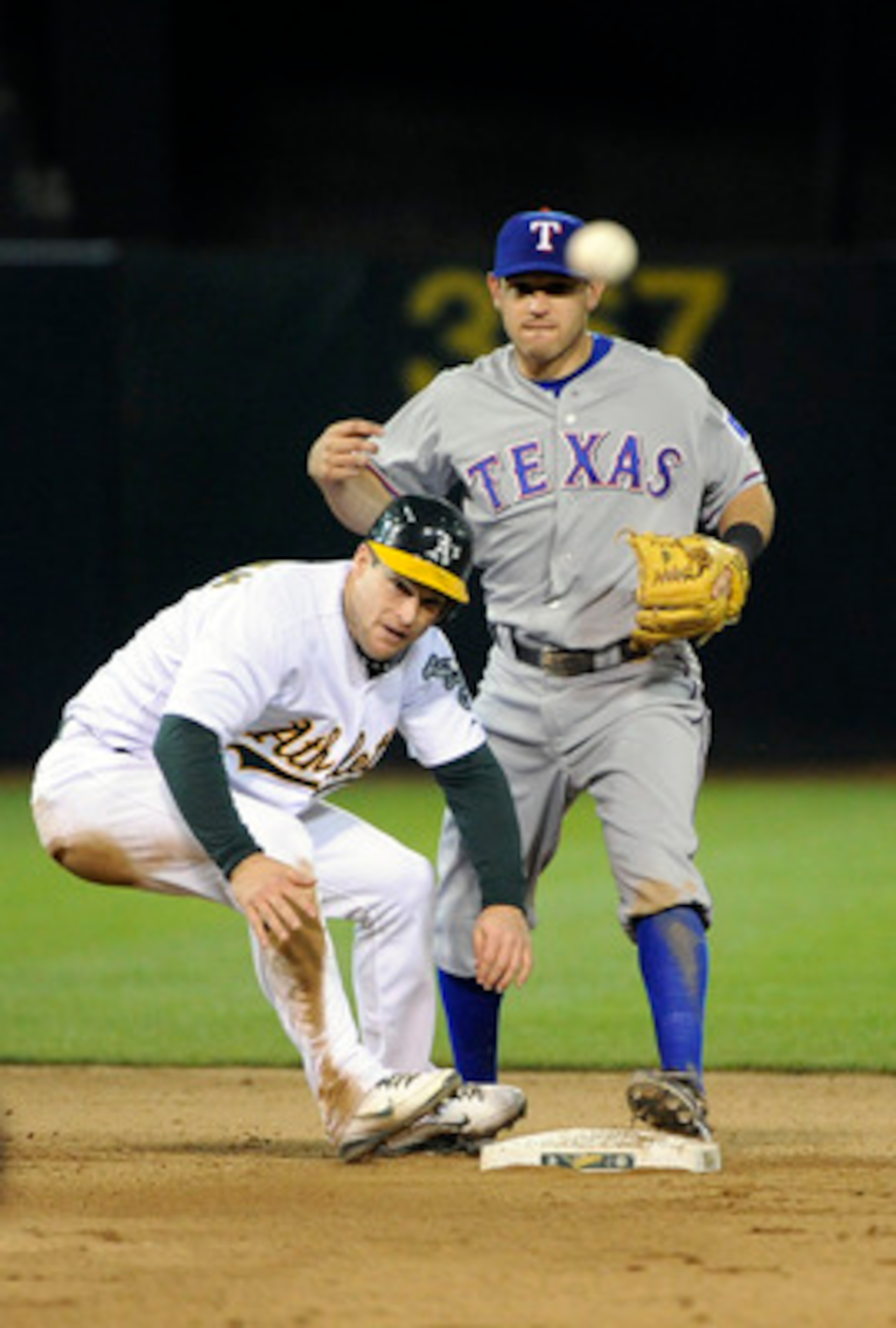 OAKLAND, CA - APRIL 29: Josh Willingham #16 of the Oakland Athletics slides into second base causing a throwing error by Ian Kinsler #5 of the Texas Rangers in the bottom of the seventh inning during a MLB game at the Oakland-Alameda County Coliseum April