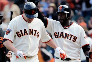SAN FRANCISCO, CA - JUNE 11: Pat Burrell #5 (L) of the San Francisco Giants is slapped on the helmet by teammate Bill Hall #29 (R) after Burrell hit a two run home run in the bottom of the ninth inning against the Cincinnati Reds during a MLB baseball gam