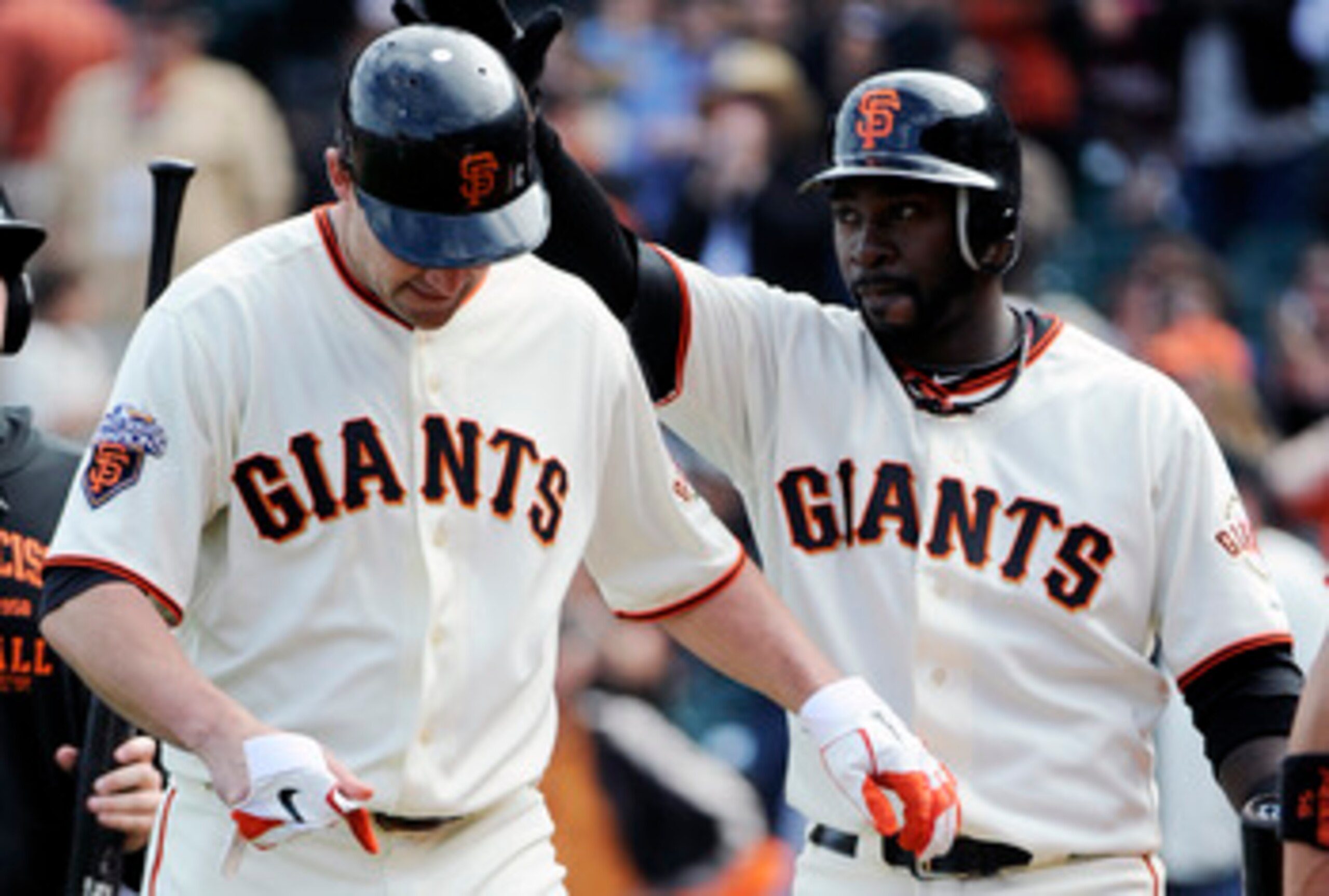 SAN FRANCISCO, CA - JUNE 11: Pat Burrell #5 (L) of the San Francisco Giants is slapped on the helmet by teammate Bill Hall #29 (R) after Burrell hit a two run home run in the bottom of the ninth inning against the Cincinnati Reds during a MLB baseball gam