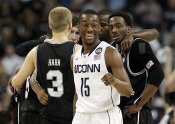 HOUSTON, TX - APRIL 04:  Kemba Walker #15 of the Connecticut Huskies smiles as the Butler Bulldogs huddle during the National Championship Game of the 2011 NCAA Division I Men's Basketball Tournament at Reliant Stadium on April 4, 2011 in Houston, Texas.