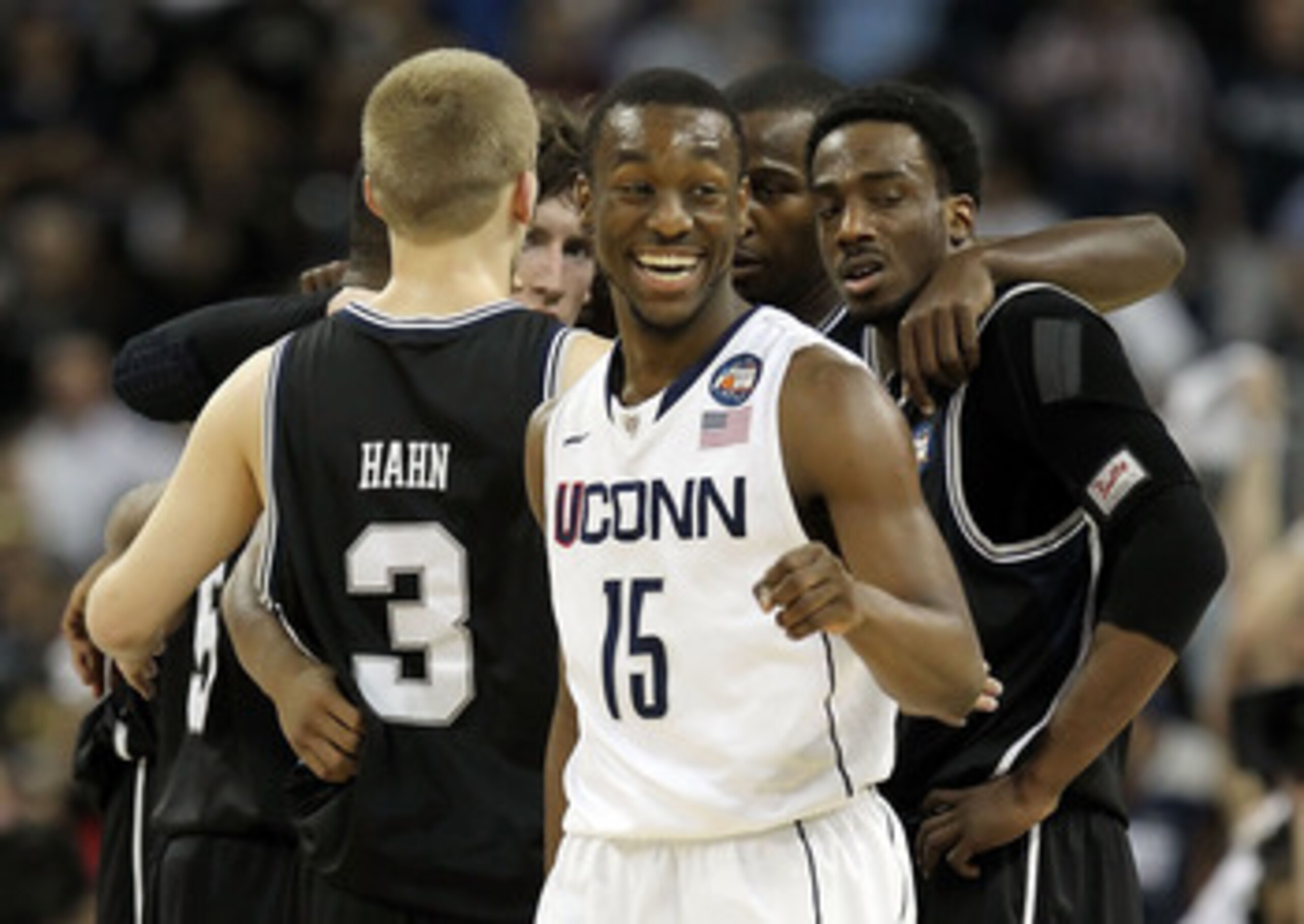 HOUSTON, TX - APRIL 04:  Kemba Walker #15 of the Connecticut Huskies smiles as the Butler Bulldogs huddle during the National Championship Game of the 2011 NCAA Division I Men's Basketball Tournament at Reliant Stadium on April 4, 2011 in Houston, Texas.