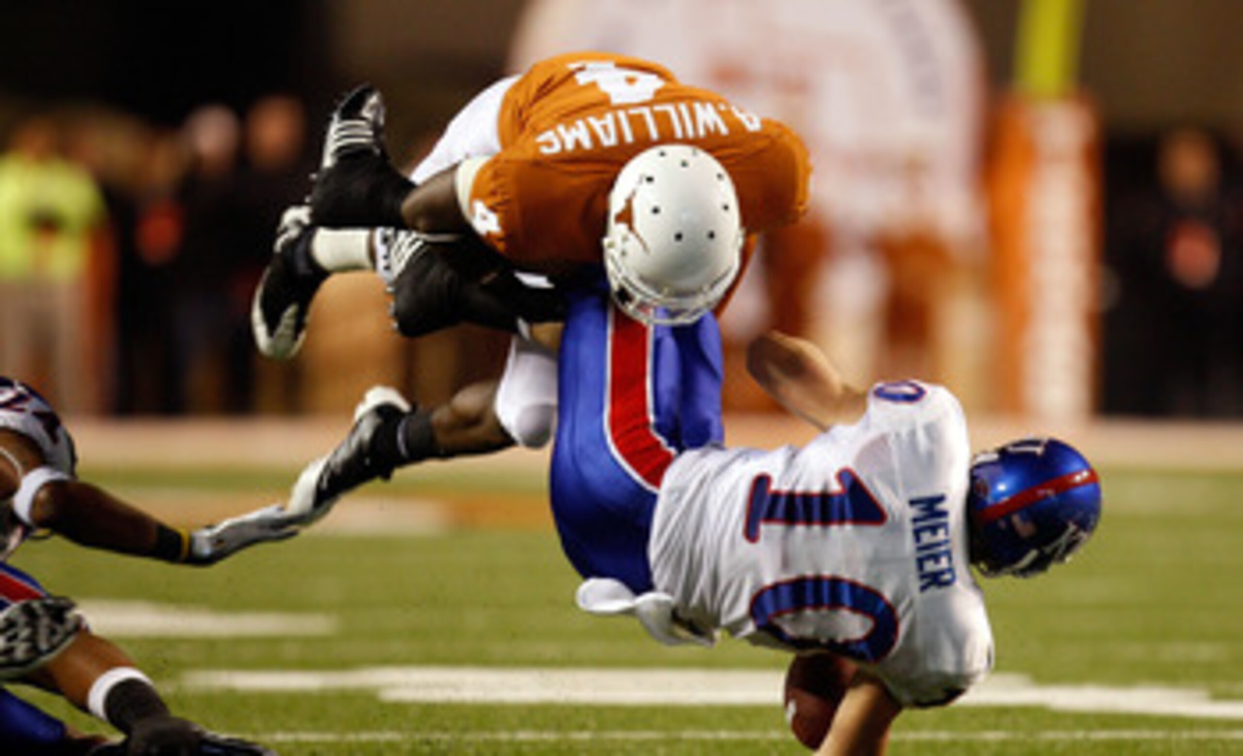 AUSTIN, TX - NOVEMBER 21:  Wide receiver Kerry Meier #10 of the Kansas Jayhawks is tackled by Aaron Williams #4 of the Texas Longhorns at Darrell K Royal-Texas Memorial Stadium on November 21, 2009 in Austin, Texas.  (Photo by Ronald Martinez/Getty Images