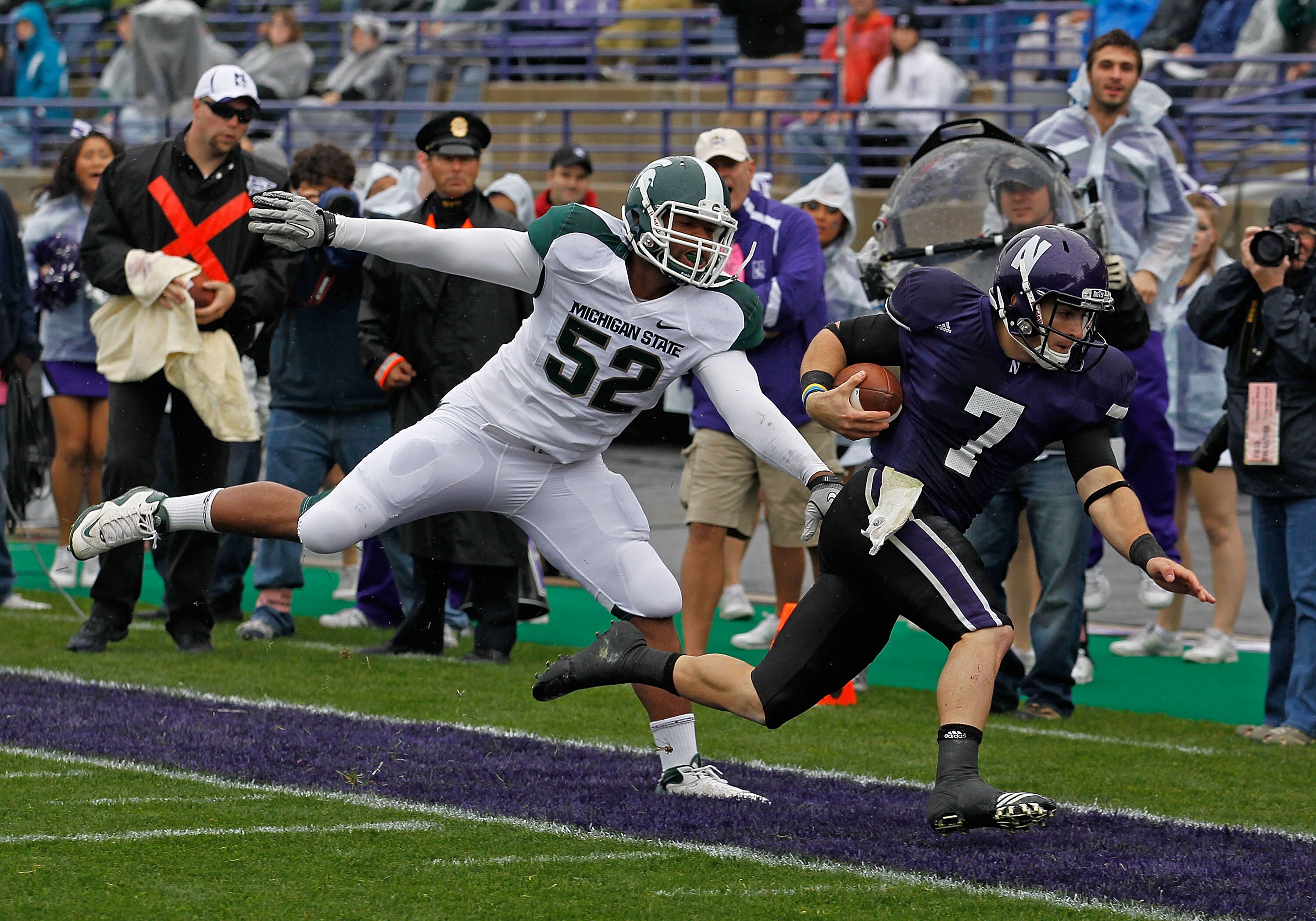 EVANSTON, IL - OCTOBER 23: Dan Persa #7 of the Northwestern Wildcats is knocked out of bounds short of the goalline by Denzel Drone #52 of the Michigan State Spartans at Ryan Field on October 23, 2010 in Evanston, Illinois. Michigan State defeated Northwe EVANSTON, IL - OCTOBER 23: Dan Persa #7 of the Northwestern Wildcats is knocked out of bounds short of the goalline by Denzel Drone #52 of the Michigan State Spartans at Ryan Field on October 23, 2010 in Evanston, Illinois. Michigan State defeated Northwe