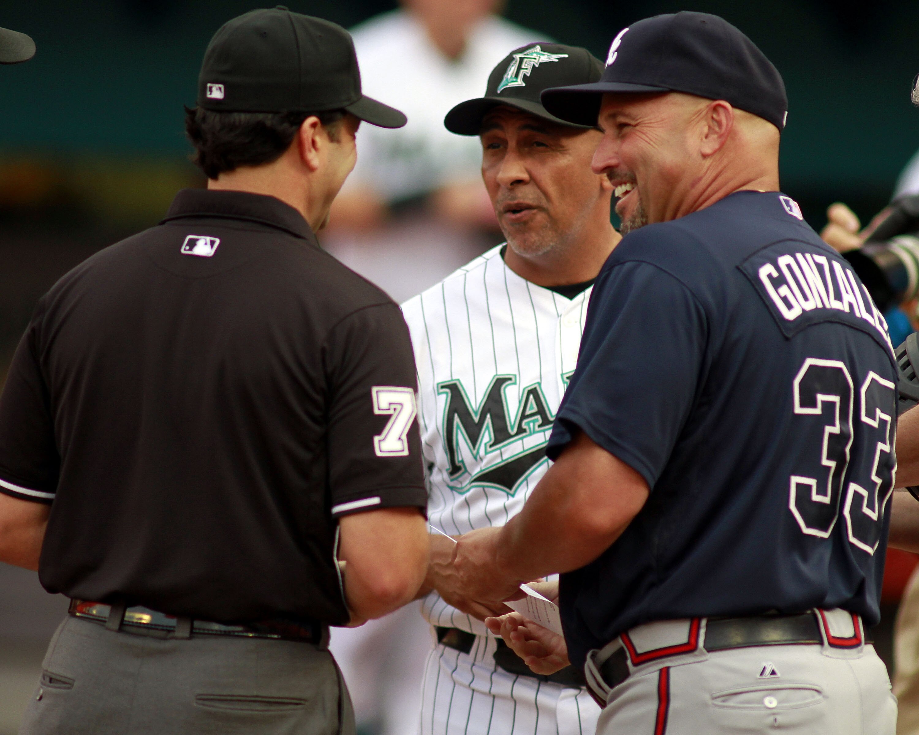 MIAMI GARDENS, FL - JUNE 07:  Manager Edwin Rodriguez of the Florida Marlins and former Marlins Manager Freddie Gonzalez #33 of the Atlanta Braves chats with the umpire prior to their game at Sun Life Stadium on June 7, 2011 in Miami Gardens, Florida.  Th