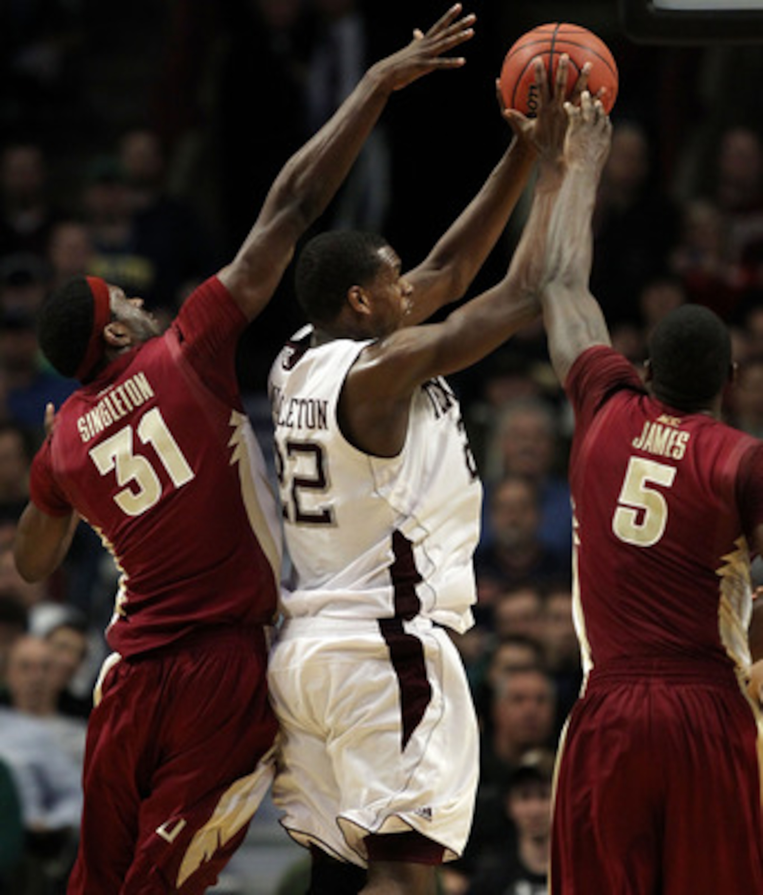 CHICAGO, IL - MARCH 18:  Khris Middleton #22 of the Texas A&M Aggies shoots against Chris Singleton #31 and Bernard James #5 of the Florida State Seminoles in the second half during the second round of the 2011 NCAA men's basketball tournament at the Unit