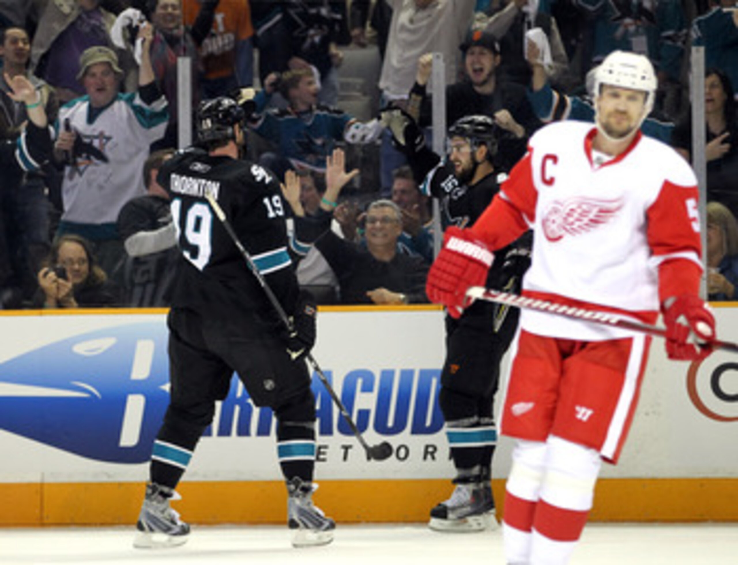 SAN JOSE, CA - MAY 08:  Joe Thornton #19 and Devin Setoguchi #16 of the San Jose Sharks celebrate behind Nicklas Lidstrom #5 of the Detroit Red Wings after Setoguchi scored a goal in Game Five of the Western Conference Semifinals during the 2011 NHL Stanl