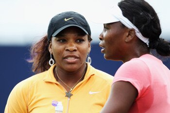 EASTBOURNE, ENGLAND - JUNE 11:  Serena Williams (L) of the USA chats to her sister Venus during a break in practice for the AEGON International on June 11, 2011 in Eastbourne, England.  (Photo by Bryn Lennon/Getty Images)
