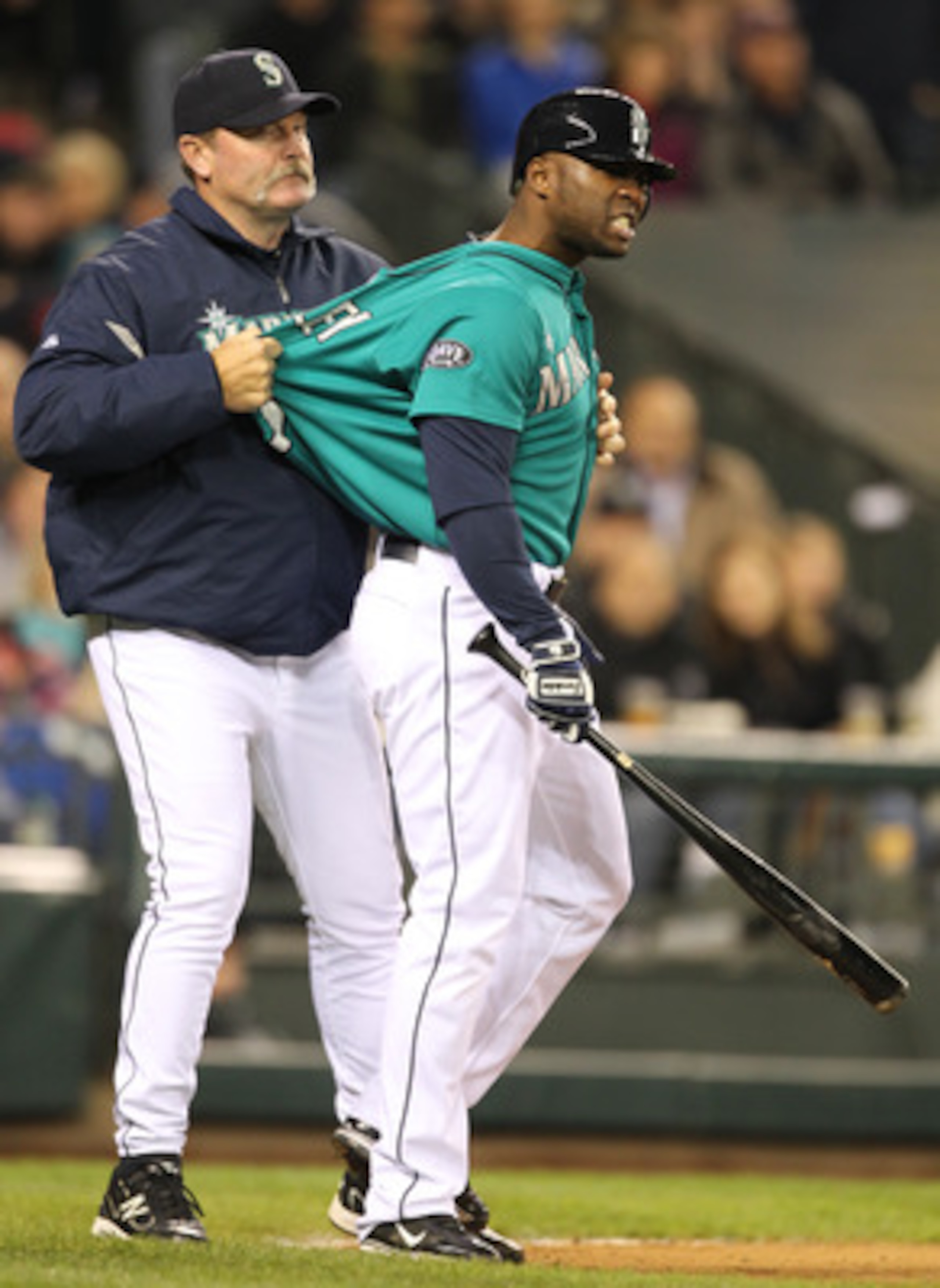 SEATTLE - MAY 06:  Milton Bradley #15 of the Seattle Mariners is restrained by manager Eric Wedge #22 after being ejected from the game against the Chicago White Sox at Safeco Field on May 6, 2011 in Seattle, Washington. The Mariners won 3-2. (Photo by Ot