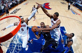 ATLANTA, GA - APRIL 28:  Gilbert Arenas #1 of the Orlando Magic drives to the basket against Josh Smith #5 and Al Horford #15 of the Atlanta Hawks during Game Six of the Eastern Conference Quarterfinals in the 2011 NBA Playoffs at Philips Arena on April 2