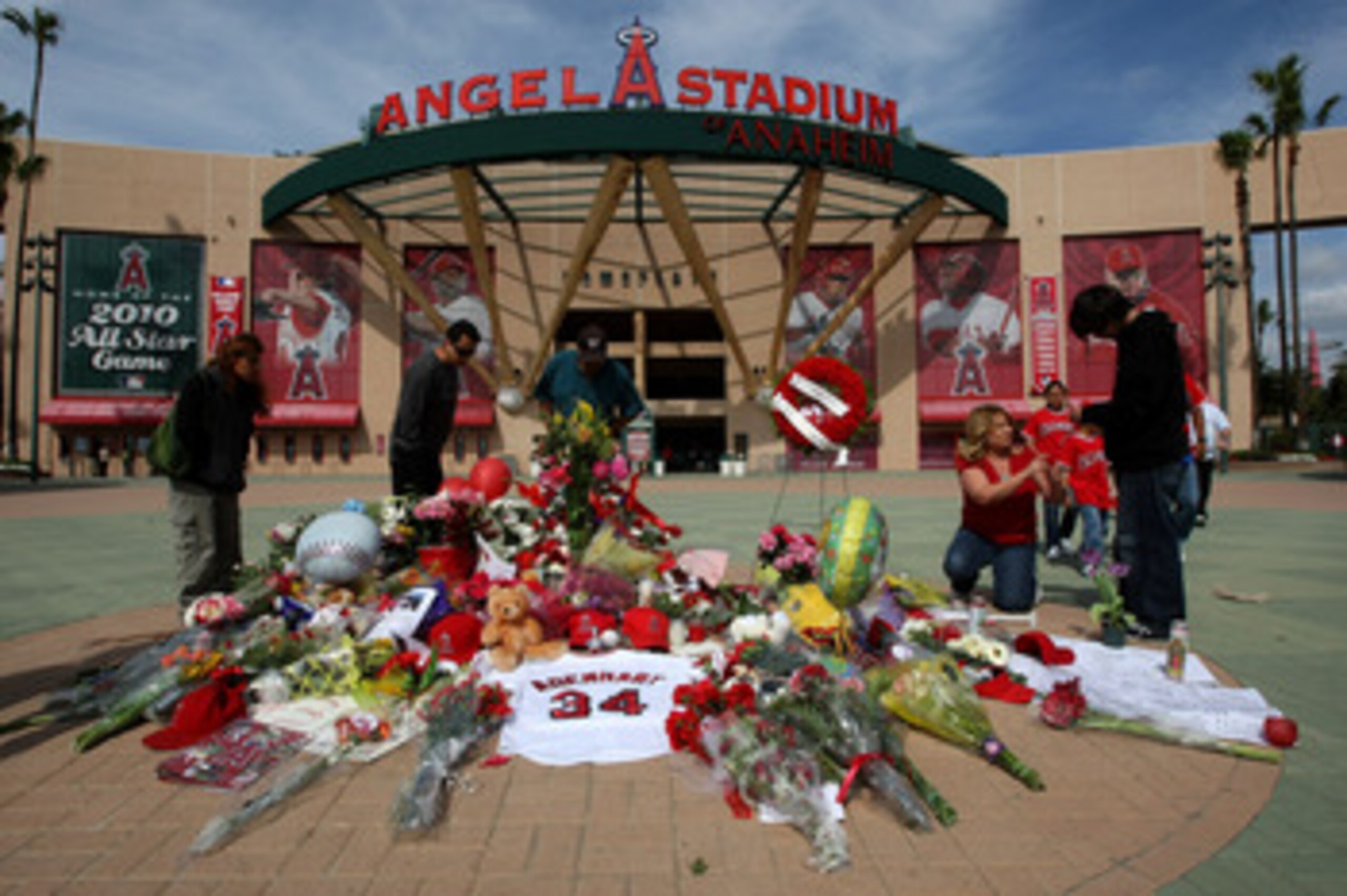 ANAHEIM, CA - APRIL 9:  Fans gather around a makeshift memorial to Los Angeles Angels of Anaheim pitcher Nick Adenhart outside Angel Stadium April 9, 2009 in Anaheim, California. Adenhart and two others were killed in car crash early this morning.  (Photo