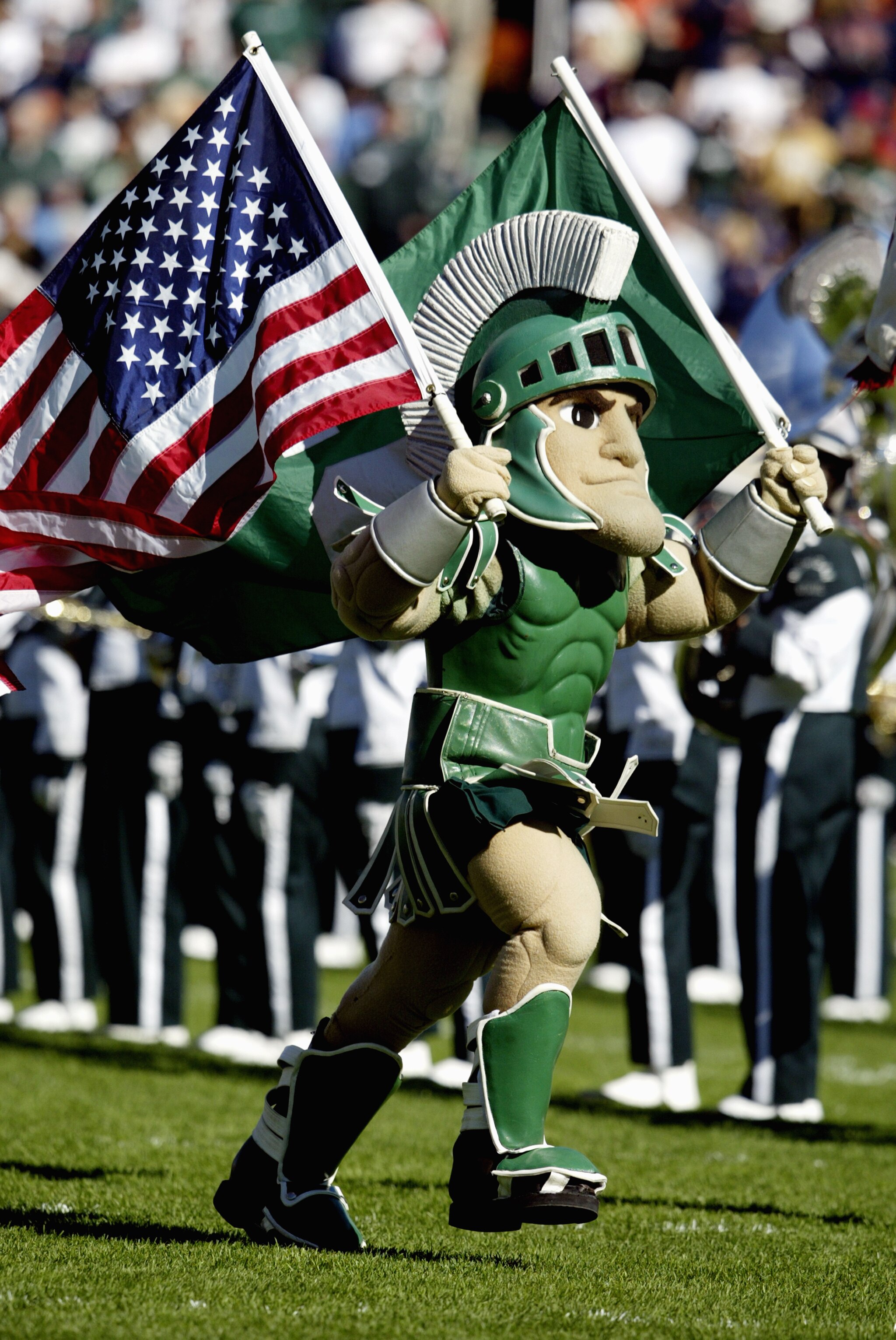 EAST LANSING, MI - OCTOBER 9:  Sparty, the Michigan State University Spartans mascot, carries the American Flag during the game against the University of Illinois Fighting Illini at Spartan Stadium on October 9, 2004 in East Lansing, Michigan. Michigan St