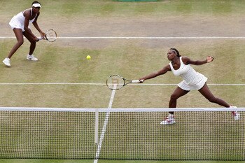 LONDON, ENGLAND - JUNE 30:  Serena Williams (R) and Venus Williams of USA in action during their Quarter Final doubles match against Elena Vesnina and Vera Zvonareva of Russia on Day Nine of the Wimbledon Lawn Tennis Championships at the All England Lawn 