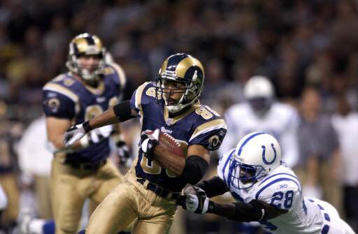 Torry Holt (#88) of the St. Louis Rams is pressured by Idrees Bashir (#28) of the Indianapolis Colts during the game at the Dome at America's Center in St. Louis, Missouri, December 30, 2001. The Colts won 42-17. (Photo by Elsa/Getty Images)