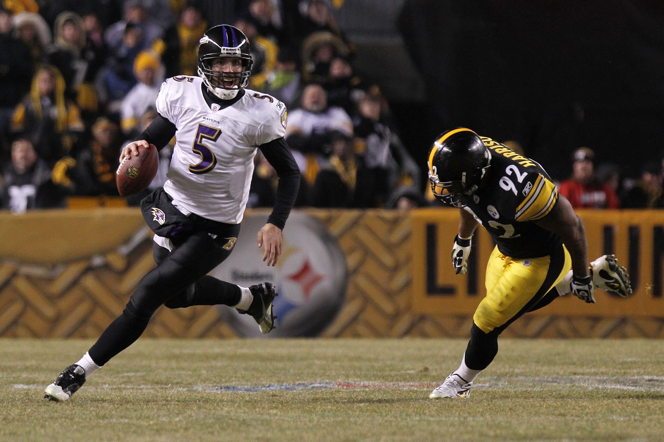 PITTSBURGH, PA - JANUARY 15:  Quarterback Joe Flacco #5 of the Baltimore Ravens runs with the ball as linebacker James Harrison #92 of the Pittsburgh Steelers chases him in the AFC Divisional Playoff Game at Heinz Field on January 15, 2011 in Pittsburgh,