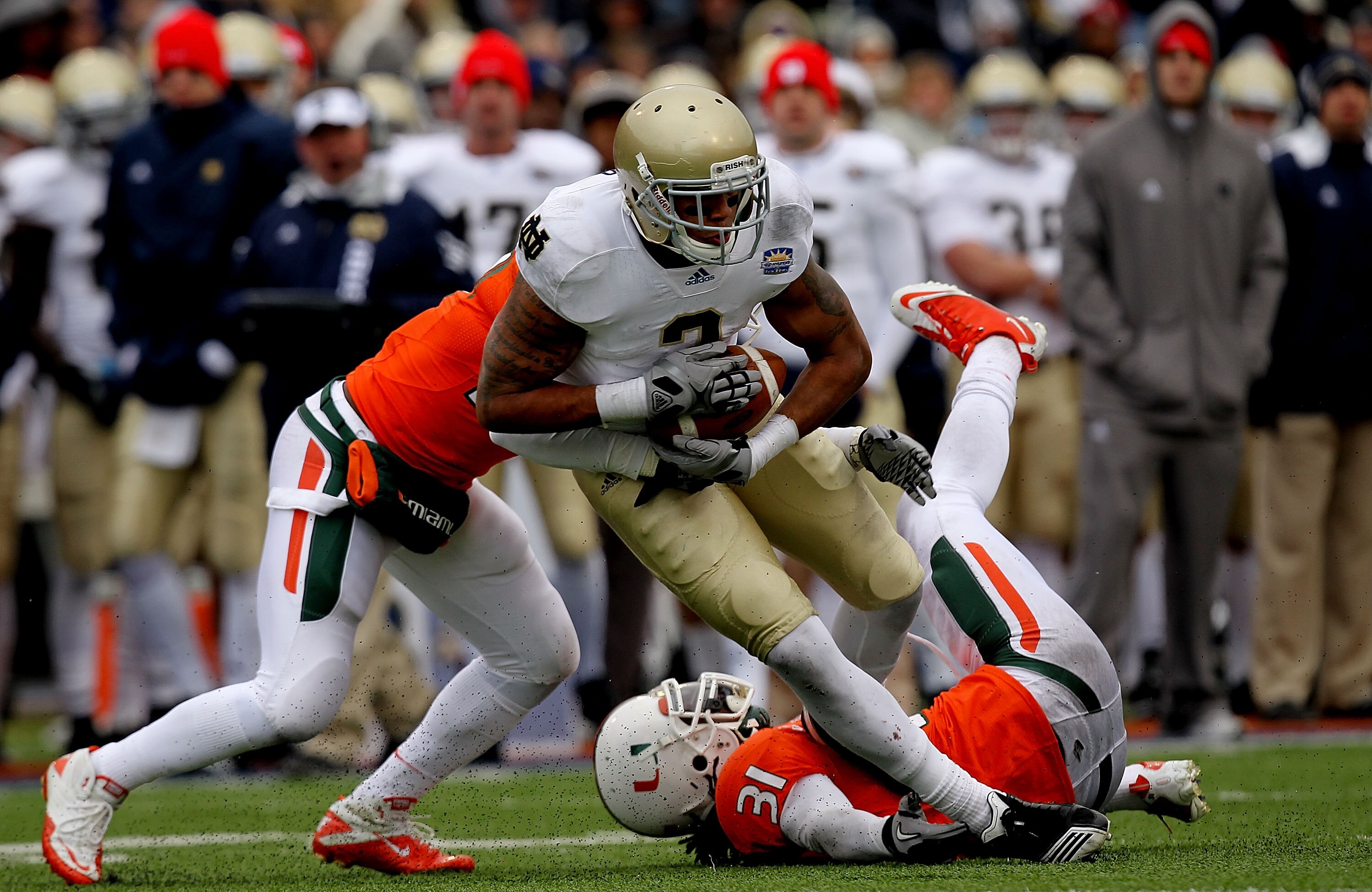EL PASO, TX - DECEMBER 30:  Wide receiver Michael Floyd #3 of the Notre Dame Fighting Irish runs the ball past Jared Campbell #37 and Sean Spence #31 of the Miami Hurricanes at Sun Bowl on December 30, 2010 in El Paso, Texas.  (Photo by Ronald Martinez/Ge