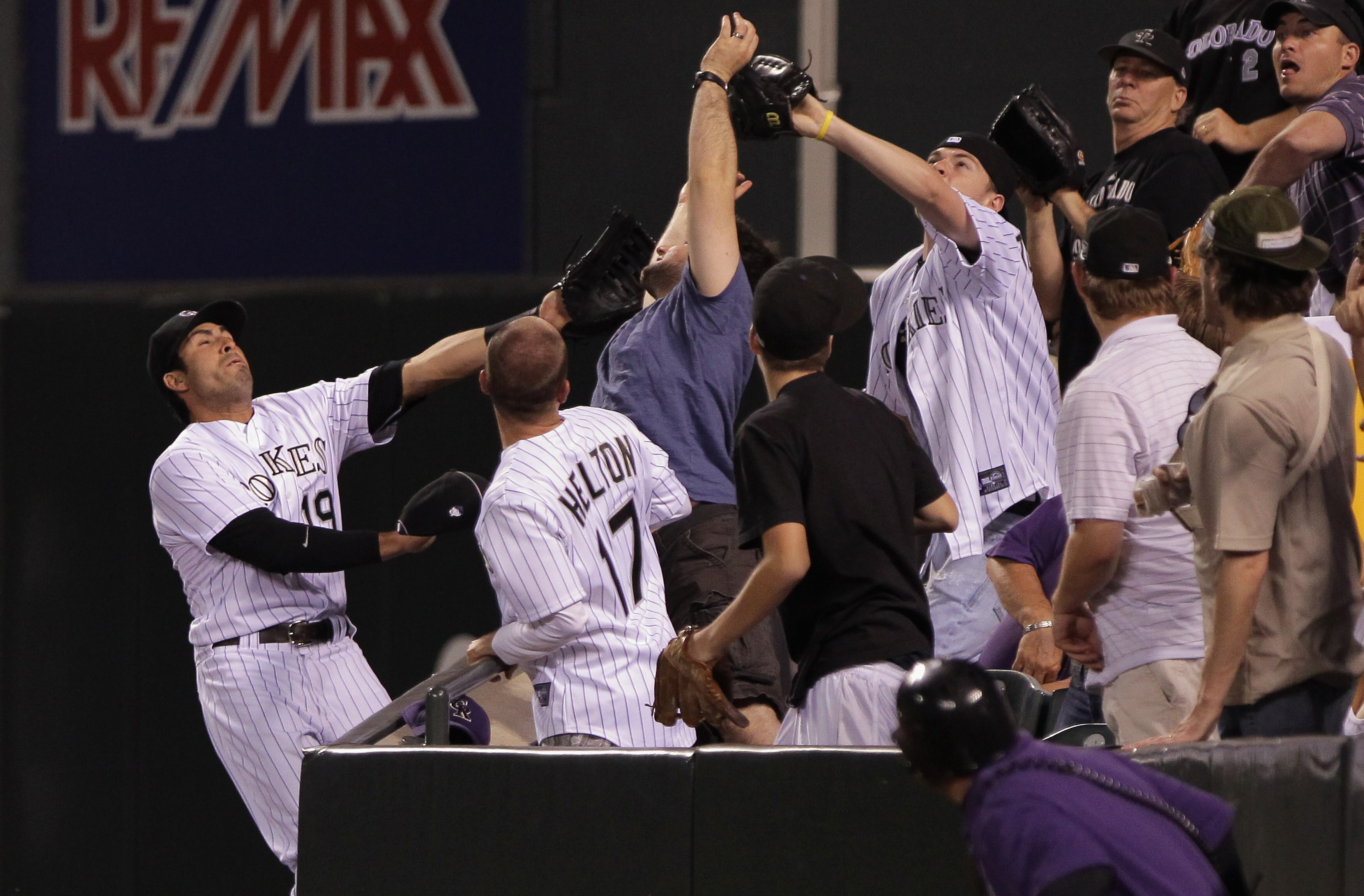 DENVER, CO - JUNE 10:  Ryan Spilborghs #19 of the Colorado Rockies fails to catch a foul ball that is caught by a fan in the rightfield stands in the ninth inning at Coors Field on June 10, 2011 in Denver, Colorado.  (Photo by Doug Pensinger/Getty Images)