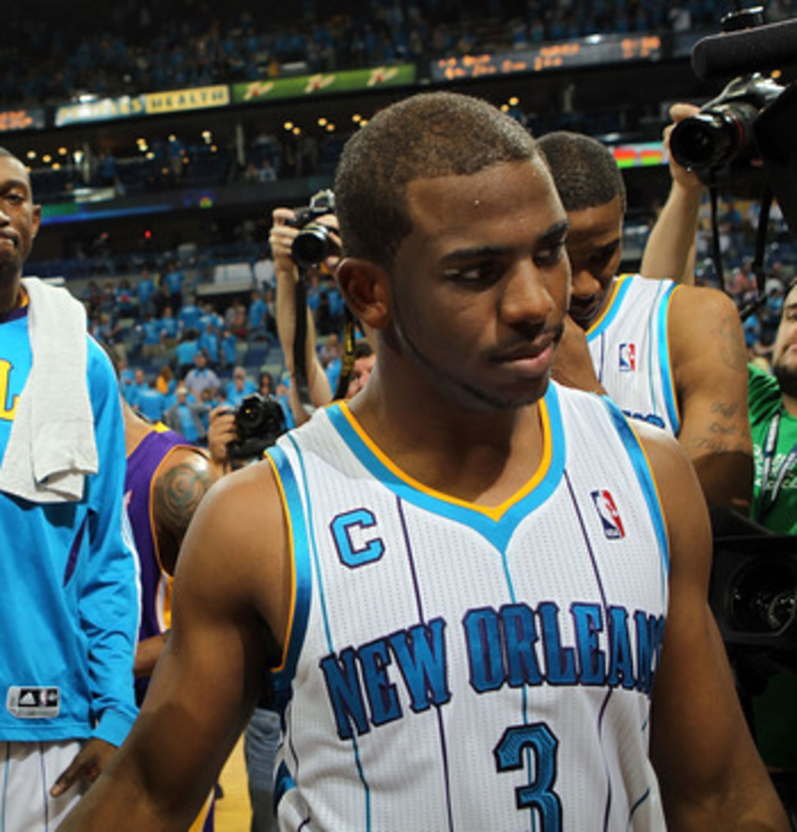 NEW ORLEANS, LA - APRIL 28:  Chris Paul #3 of the New Orleans Hornets walks off the court after a 98-80 loss as Kobe Bryant #24 of the Los Angeles Lakers smiles after winning the series in Game Six of the Western Conference Quarterfinals in the 2011 NBA P