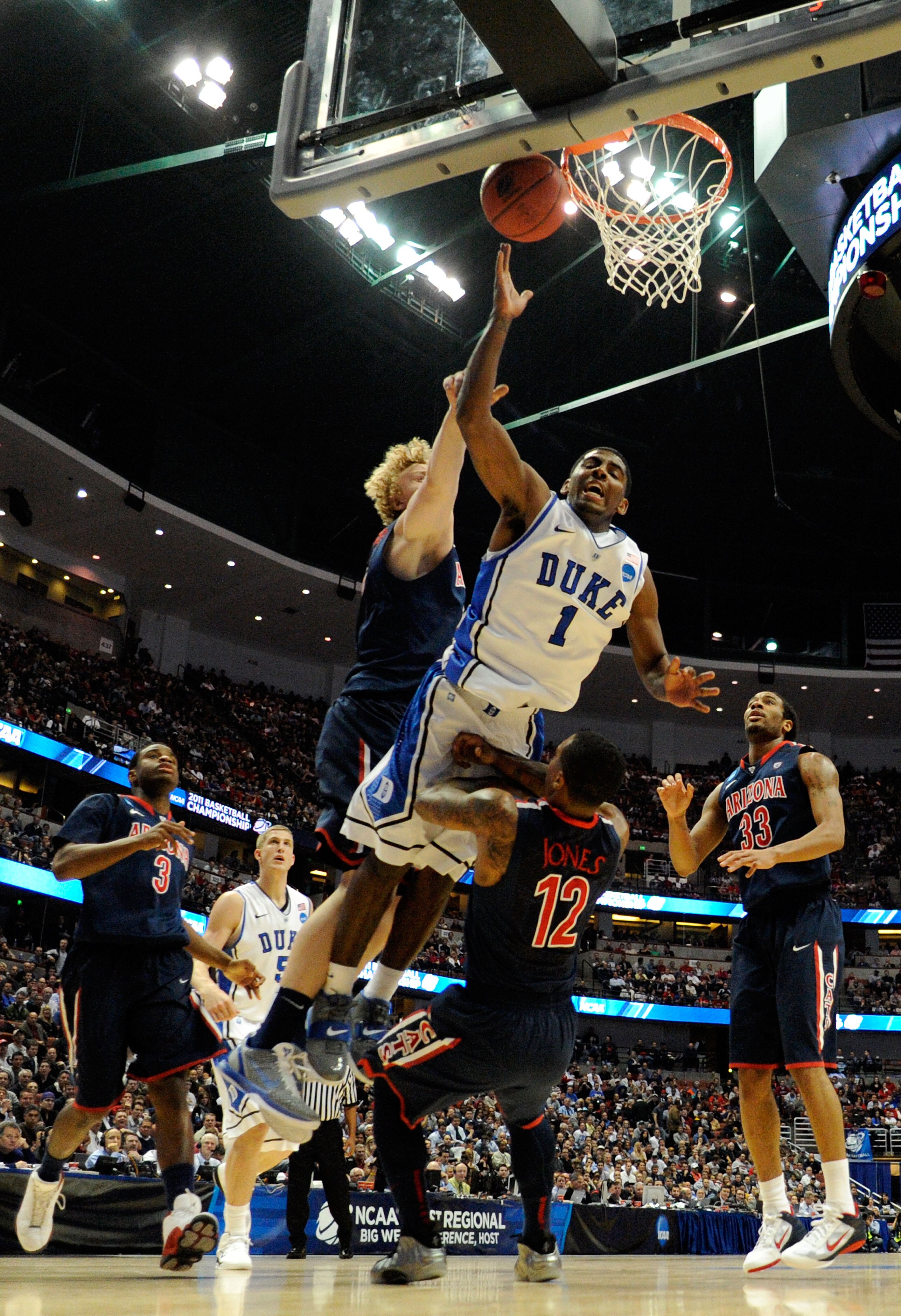 ANAHEIM, CA - MARCH 24: Kyrie Irving #1 of the Duke Blue Devils draws contact against Kyryl Natyazhko #1 and Lamont Jones #12 of the Arizona Wildcats during the west regional semifinal of the 2011 NCAA men's basketball tournament at the Honda Center on M ANAHEIM, CA - MARCH 24: Kyrie Irving #1 of the Duke Blue Devils draws contact against Kyryl Natyazhko #1 and Lamont Jones #12 of the Arizona Wildcats during the west regional semifinal of the 2011 NCAA men's basketball tournament at the Honda Center on M