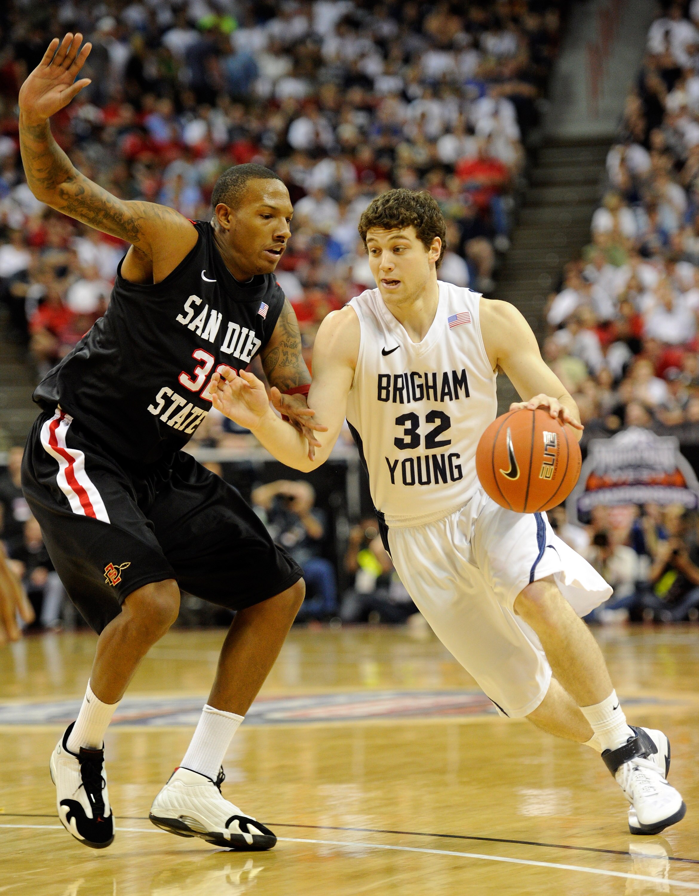 LAS VEGAS, NV - MARCH 12:  Jimmer Fredette #32 of the Brigham Young University Cougars drives agianst Billy White #32 of the San Diego State Aztecs during the championship game of the Conoco Mountain West Conference Basketball tournament at the Thomas & M