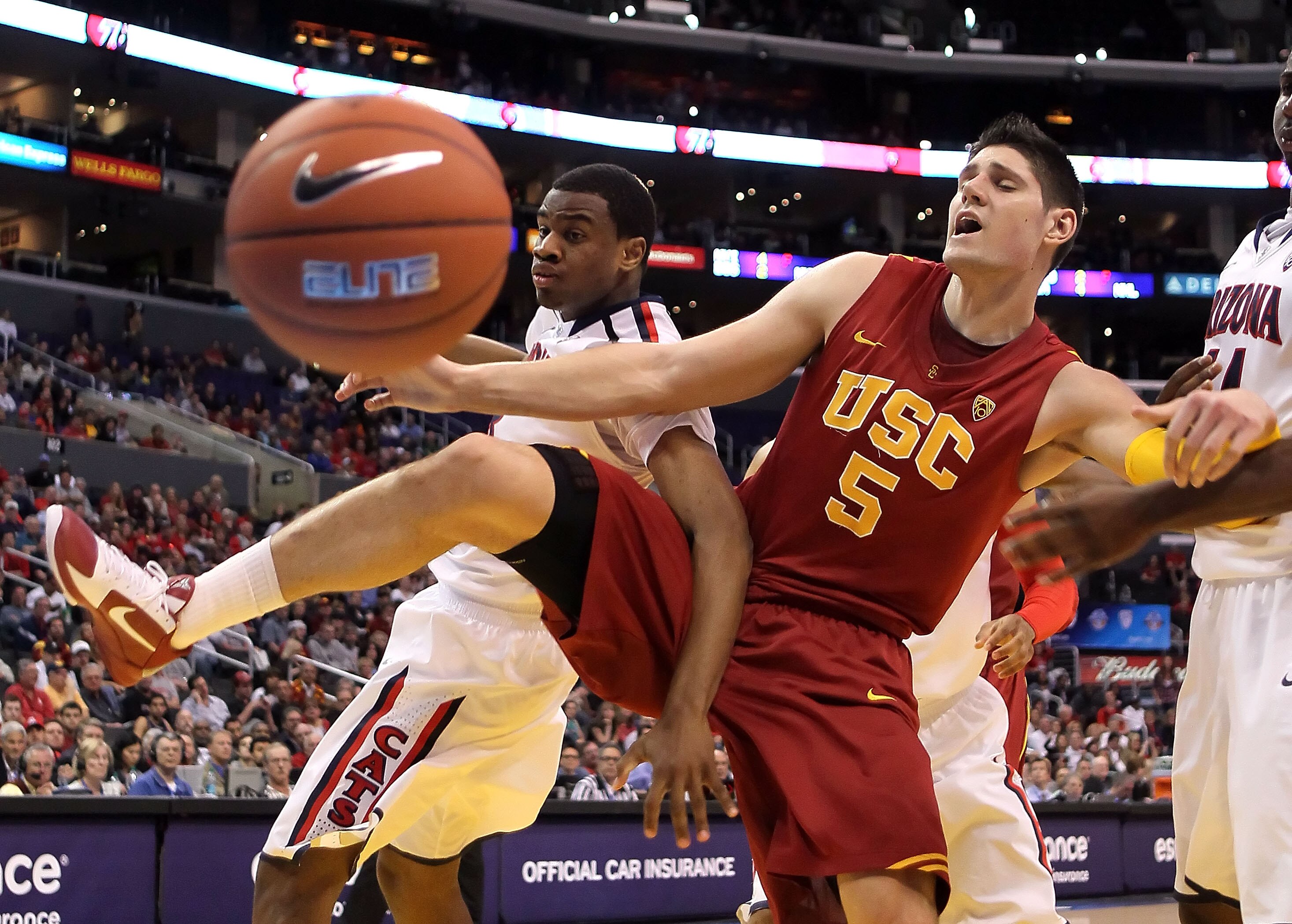 LOS ANGELES, CA - MARCH 11:  Kevin Parrom #3 of the Arizona Wildcats and Nikola Vucevic #5 of the USC Trojans battle for a loose ball in the first half in the semifinals of the 2011 Pacific Life Pac-10 Men's Basketball Tournament at Staples Center on Marc