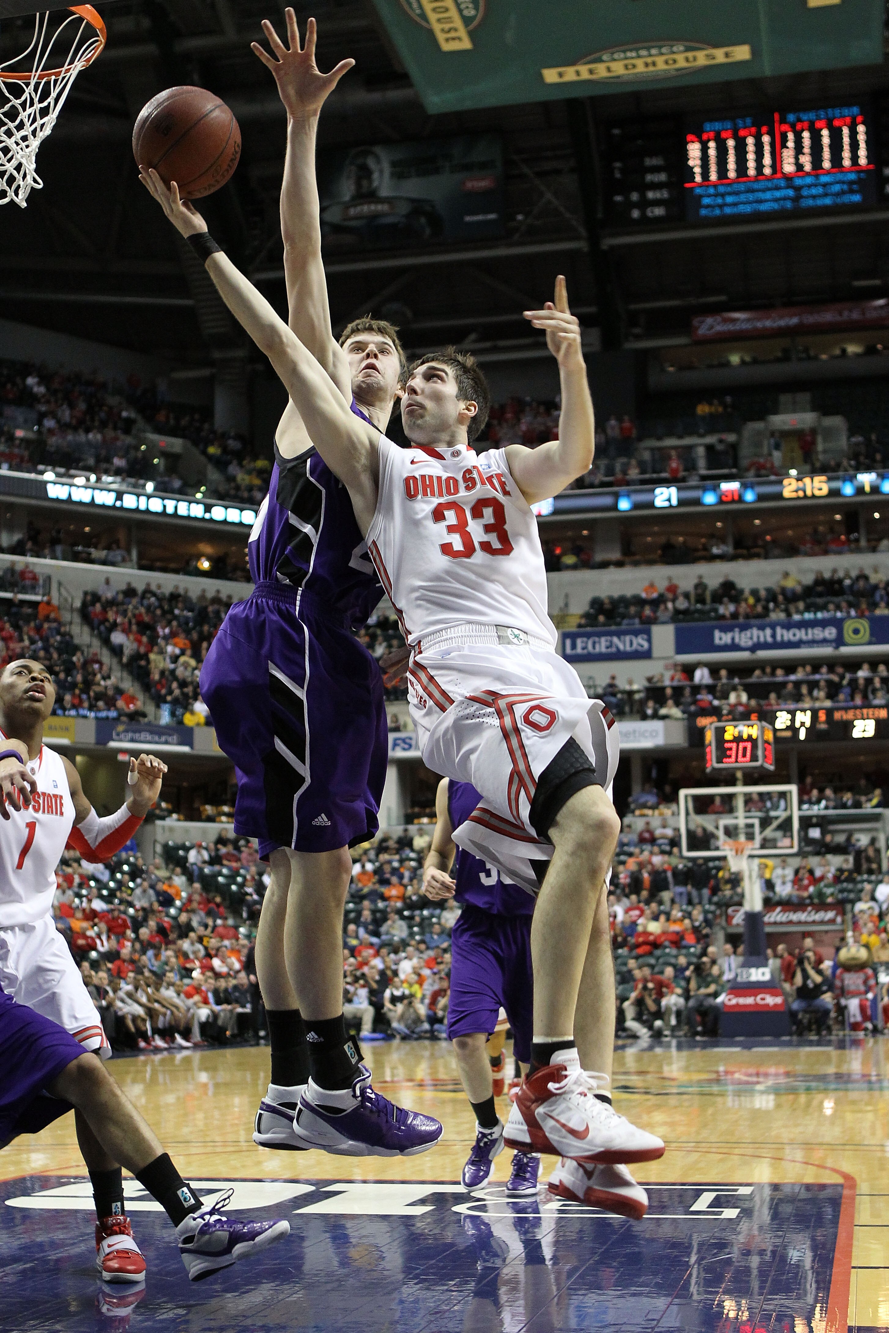 INDIANAPOLIS, IN - MARCH 11:  Jon Diebler #33 of the Ohio State Buckeyes drives for a shot attempt against John Shurna #24 of the Northwestern Wildcats during the quarterfinals of the 2011 Big Ten Men's Basketball Tournament at Conseco Fieldhouse on March