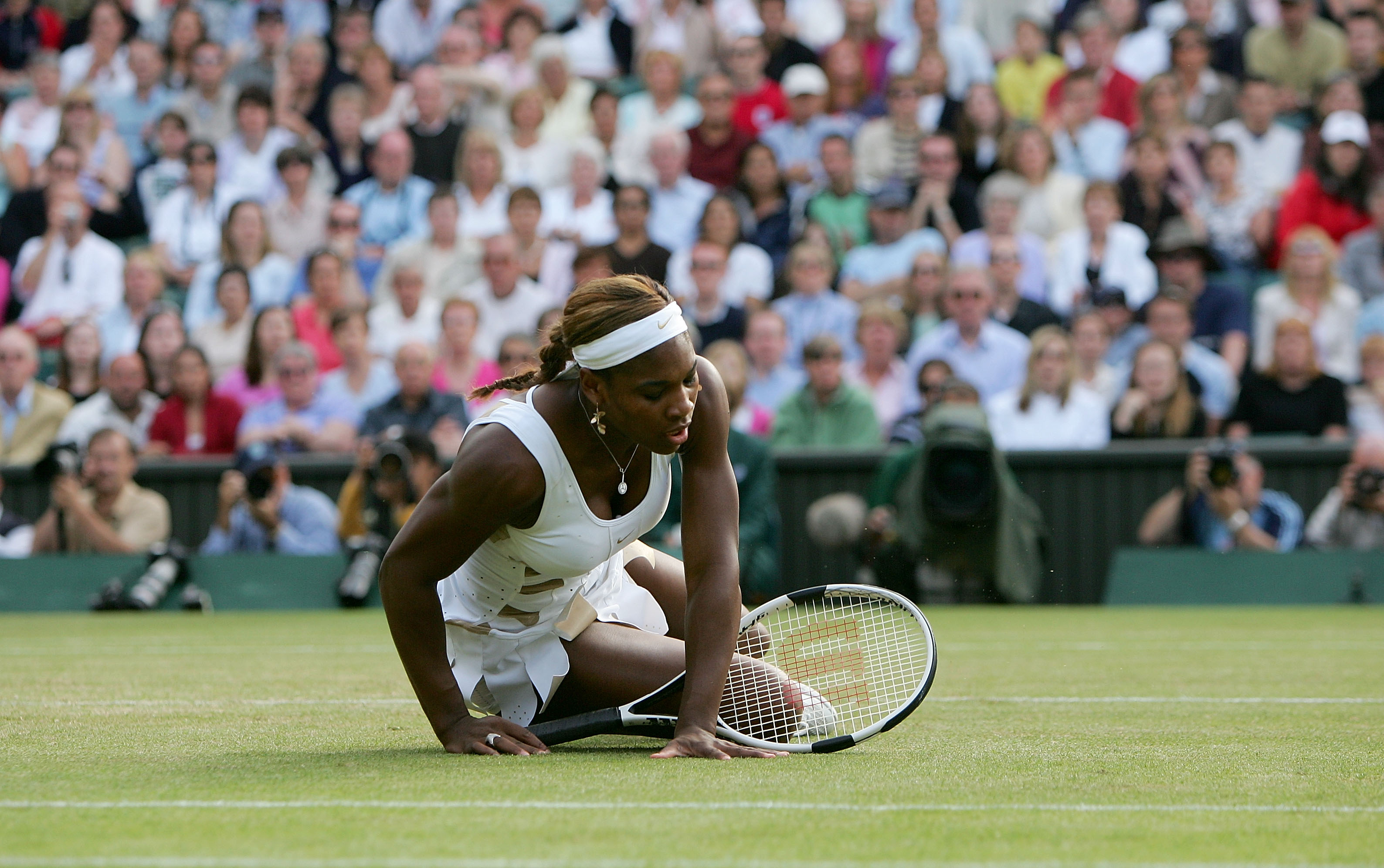 LONDON - JULY 1:  Serena Williams of USA falls down during her semi final match against Amelie Mauresmo of France at the Wimbledon Lawn Tennis Championship on July 1, 2004 at the All England Lawn Tennis and Croquet Club in London.(Photo by Mike Hewitt/Get