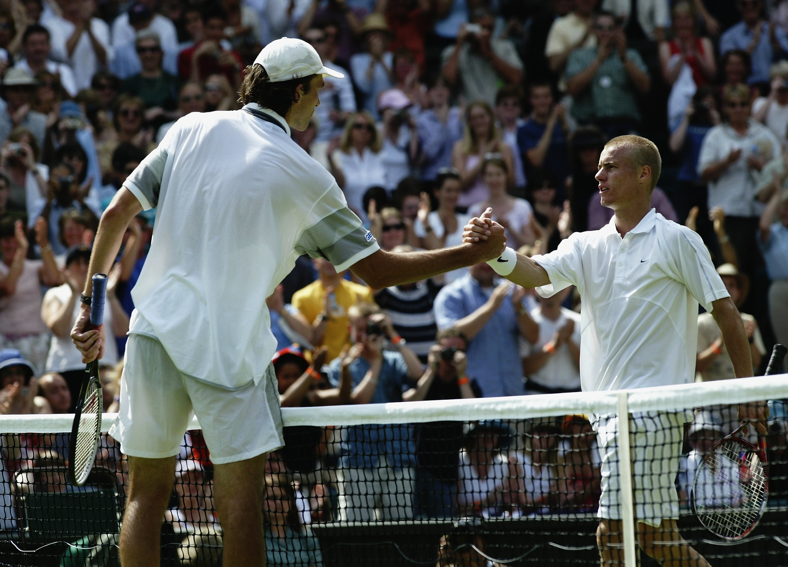 LONDON - JUNE 23:  Ivo Karlovic of Croatia shakes hands at the net after beating defending champion Lleyton Hewitt of Australia during the opening day of the Wimbledon Lawn Tennis Championships held on June 23, 2003 at the All England Lawn Tennis and Croq