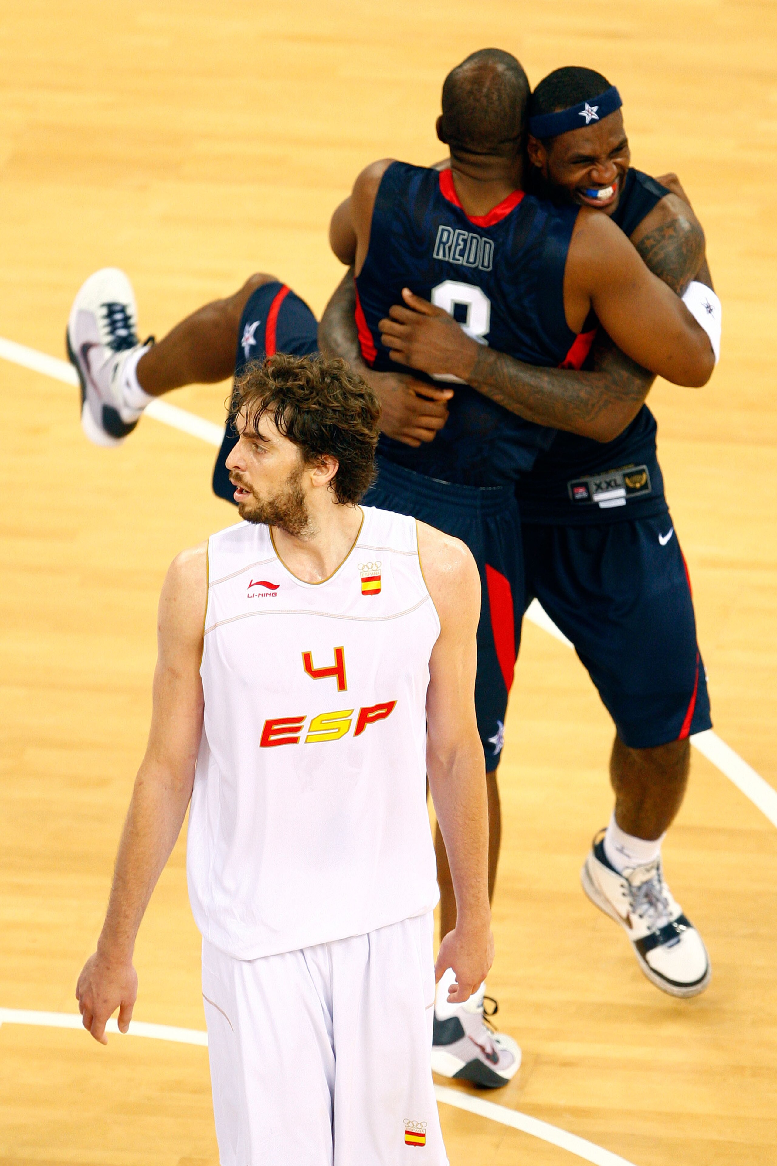 BEIJING - AUGUST 24:  LeBron James #6 and Michael Redd #8 of the United States celebrate winning the gold medal game 118-107 over Spain as Pau Gasol walks off the court during Day 16 of the Beijing 2008 Olympic Games at the Beijing Olympic Basketball Gymn