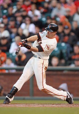 SAN FRANCISCO, CA - JUNE 12:  Nate Schierholtz #12 of the San Francisco Giants hits a sacrifice fly that scored Chris Stewart #37 of the San Francisco Giants for the go ahead run in the seventh inning against the Cincinnati Reds at AT&T Park on June 12, 2