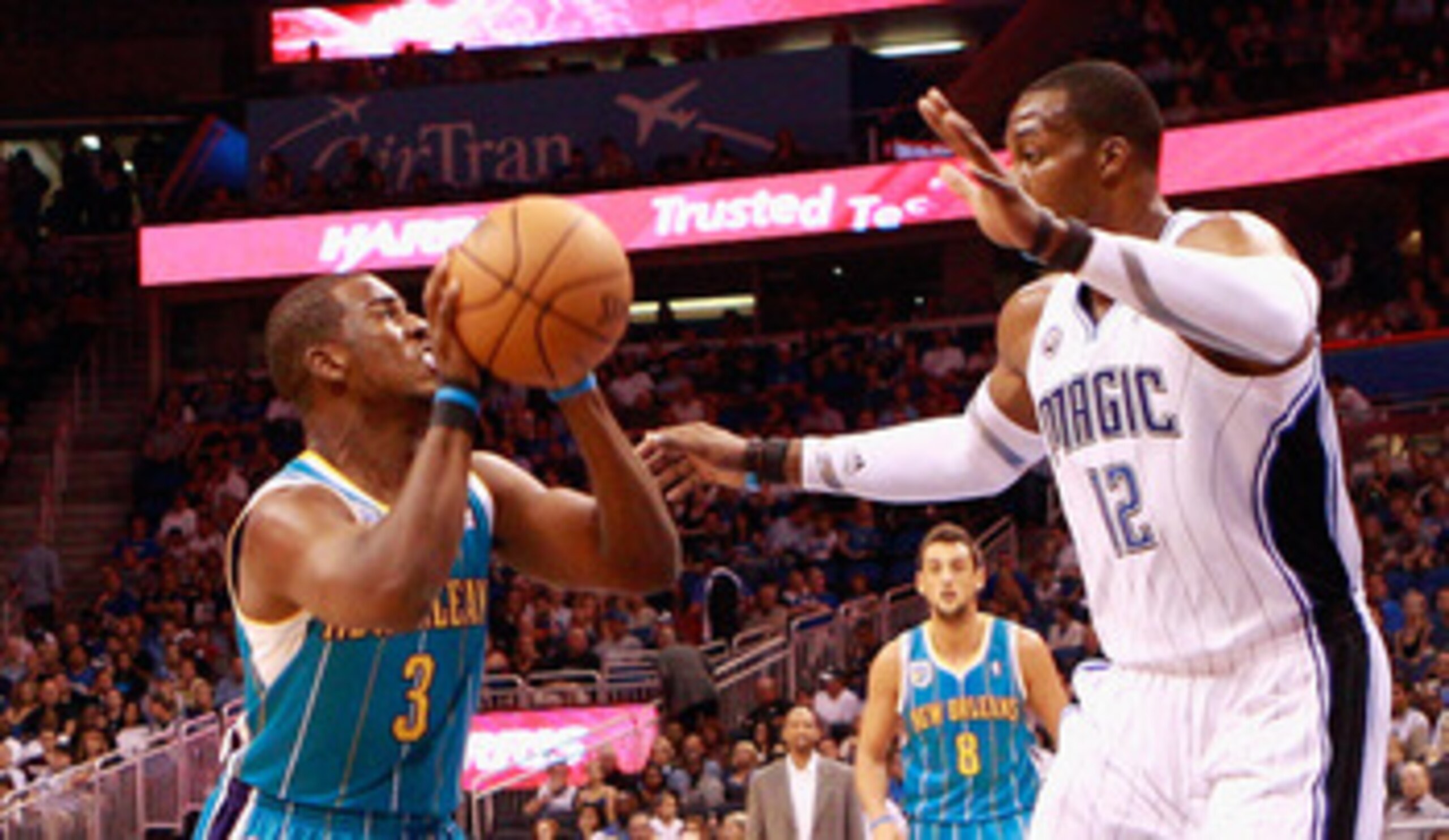 ORLANDO, FL - OCTOBER 10:  Chris Paul #3 of the New Orleans Hornets attempts a shot against Dwight Howard #12 of the Orlando Magic during the game at Amway Arena on October 10, 2010 in Orlando, Florida. NOTE TO USER: User expressly acknowledges and agrees