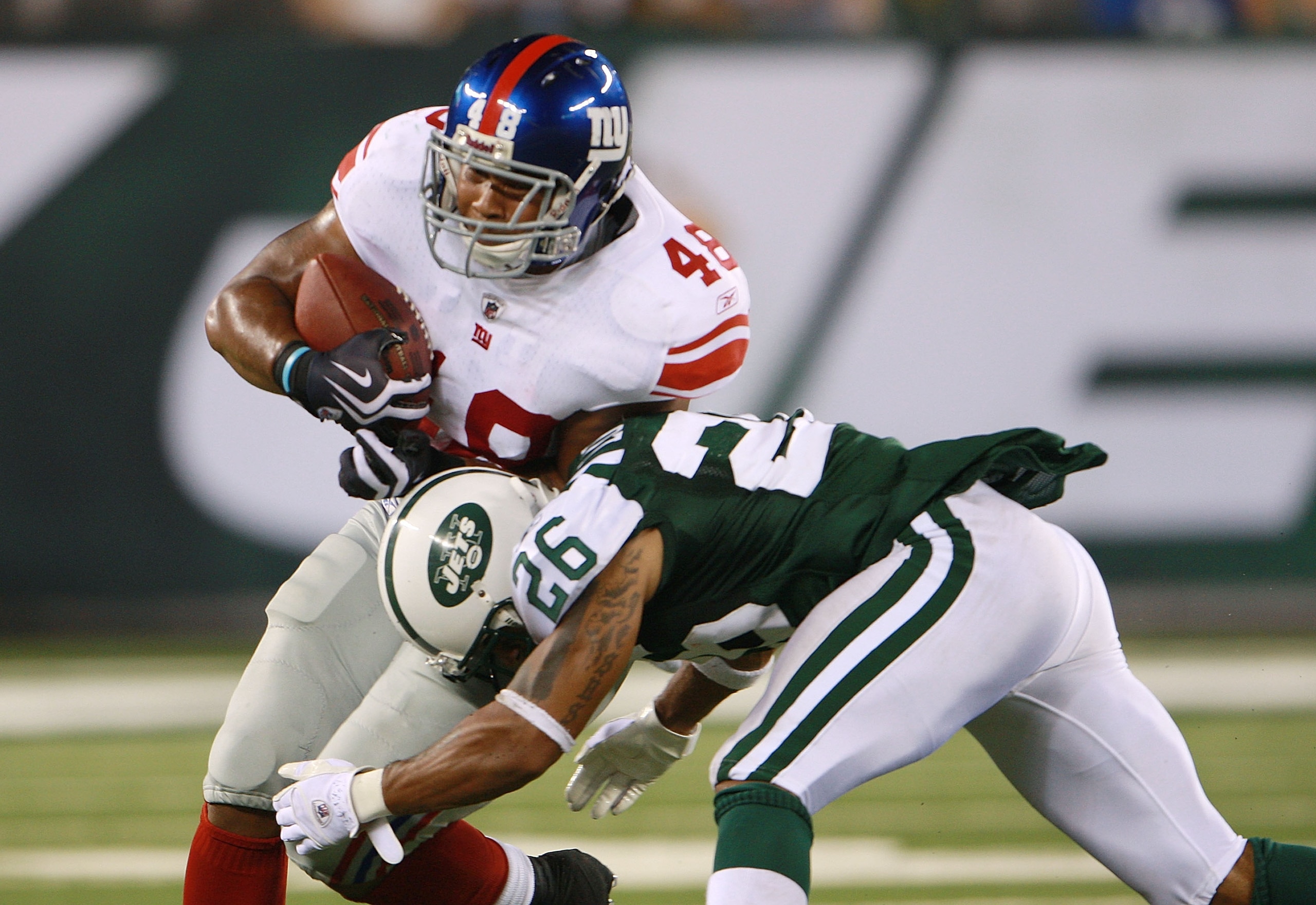 EAST RUTHERFORD, NJ - AUGUST 16:  Jerome Johnson #48 of the New York Giants attempts to break a tackle from Dwight Lowery #26 of the New York Jets during the preseason game at New Meadowlands Stadium on August 16, 2010 in East Rutherford, New Jersey. The