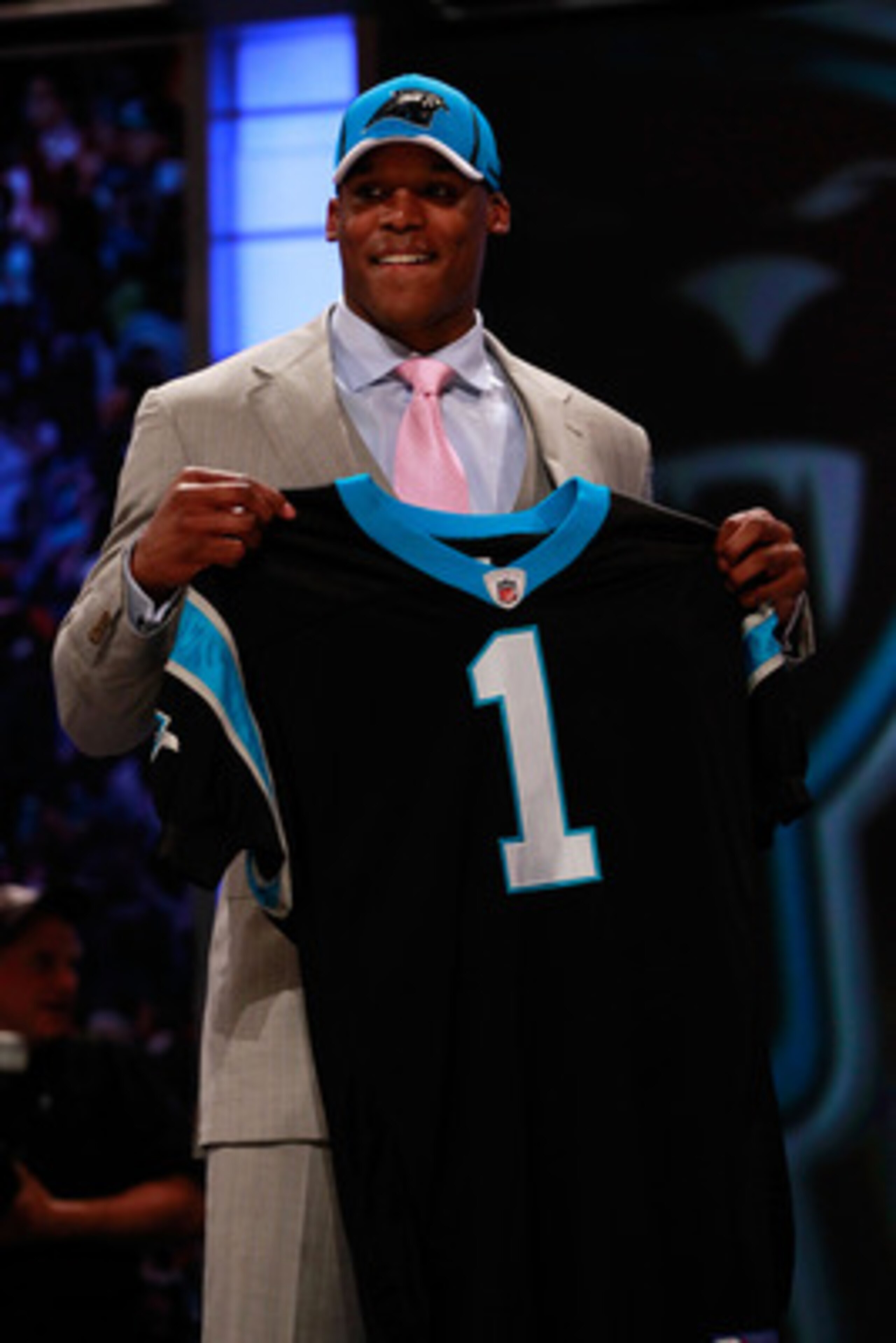 NEW YORK, NY - APRIL 28:  Cam Newton, #1 overall pick by the Carolina Panthers holds up a jersey on stage after he was picked during the 2011 NFL Draft at Radio City Music Hall on April 28, 2011 in New York City.  (Photo by Chris Trotman/Getty Images)