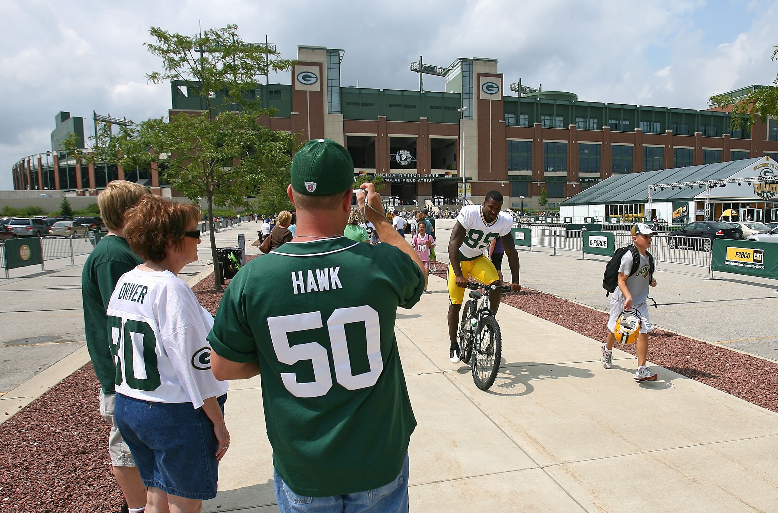GREEN BAY, WI - AUGUST 03: Fans take pictures as James Jones #89 of the Green Bay Packers rides a bike to practice during at summer training camp on August 3, 2009 at the Ray Nitschke Field in Green Bay, Wisconsin. (Photo by Jonathan Daniel/Getty Images)