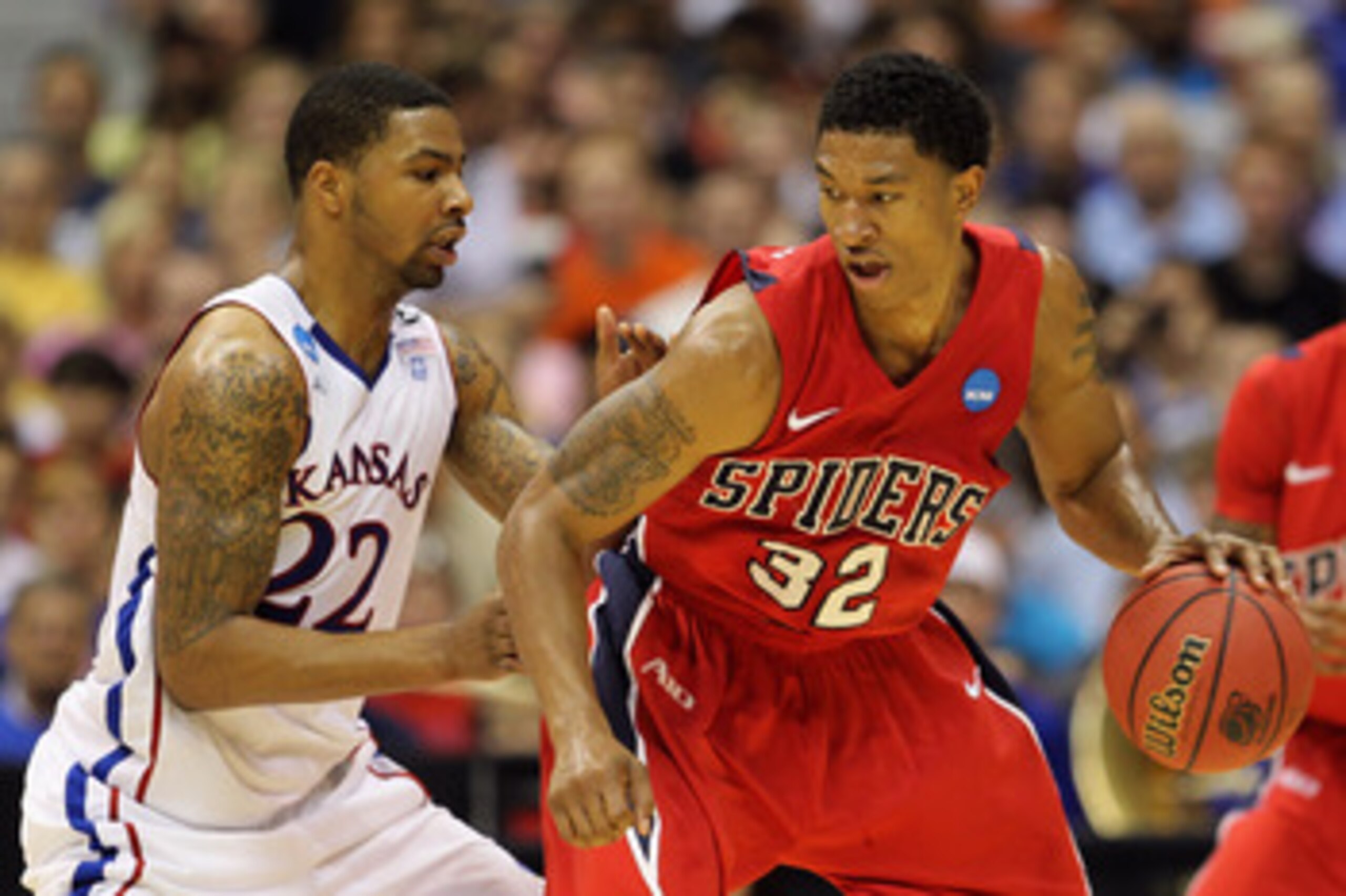 SAN ANTONIO, TX - MARCH 25:  Justin Harper #32 of the Richmond Spiders handles the ball against Marcus Morris #22 of the Kansas Jayhawks during the southwest regional of the 2011 NCAA men's basketball tournament at the Alamodome on March 25, 2011 in San A