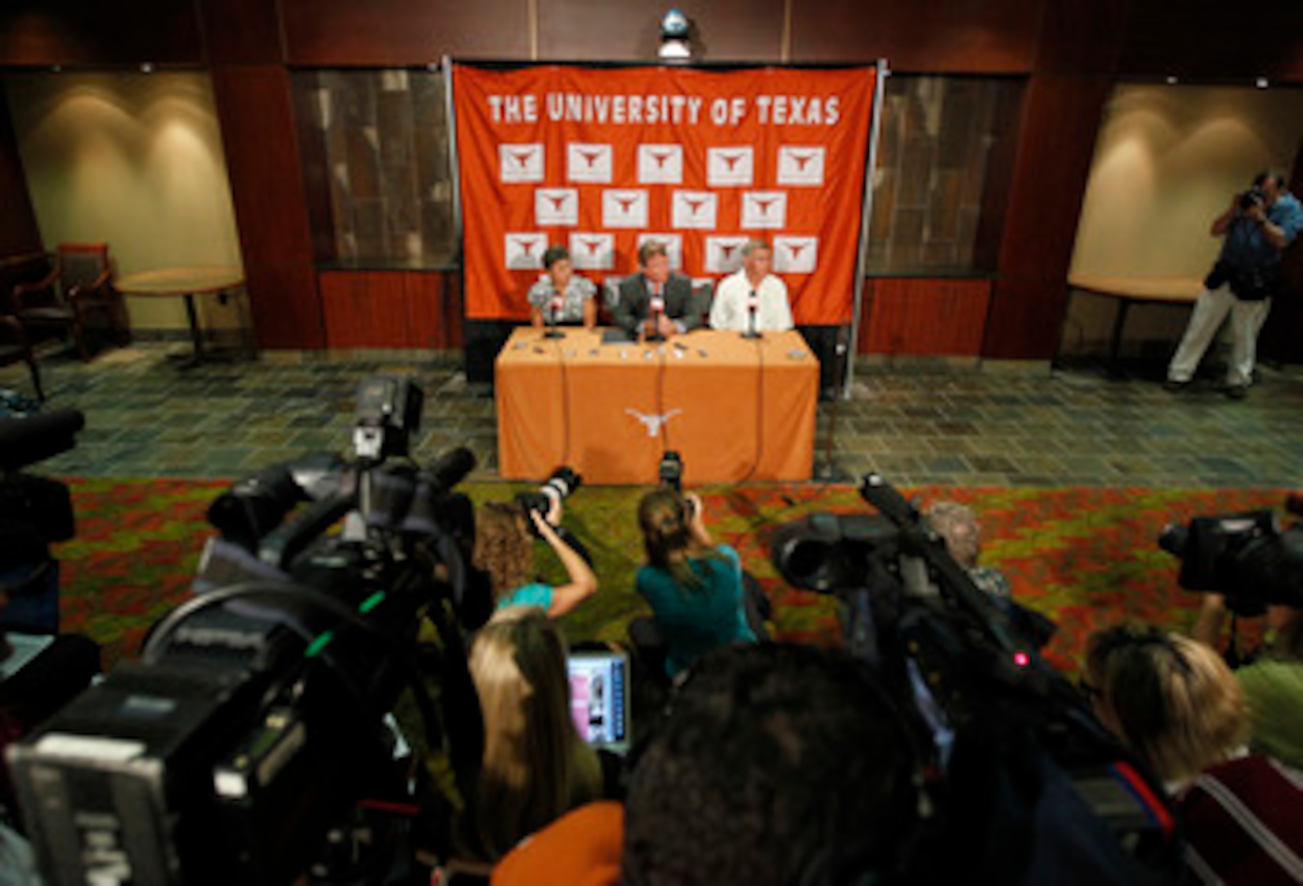 AUSTIN, TX - JUNE 15:  University of Texas at Austin President William Powers Jr., center, Women's Athletics Director Chris Plonskon, left, and Men's Athletics Director DeLoss Dodds, right, announce the athletics programs will continue competing in the Bi