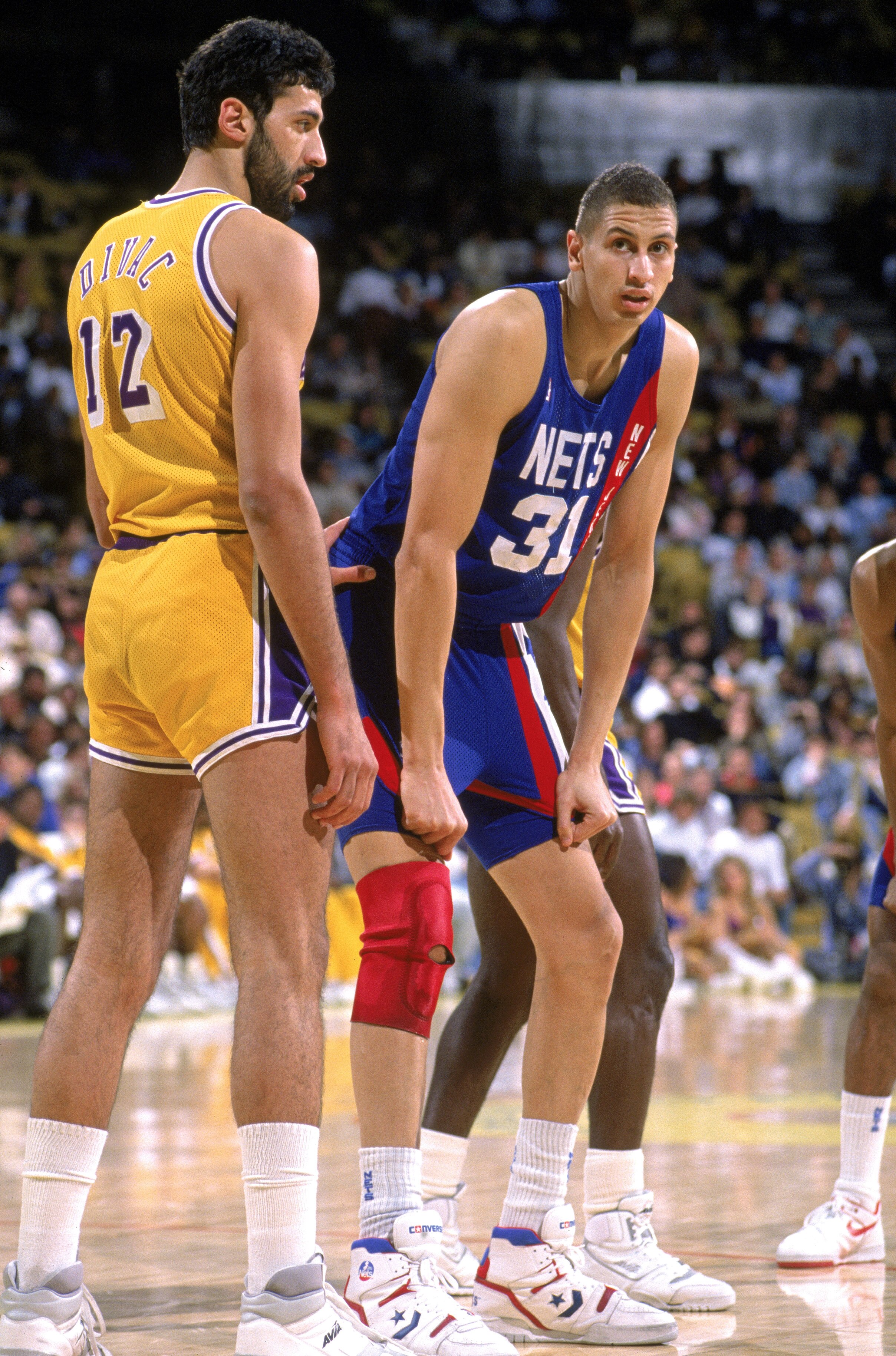LOS ANGELES - 1990:  Sam Bowie #31 of the New Jersey Nets stands ready for play next to Vlade Divac #12 of the Los Angeles Lakers during the NBA game at the Great Western Forum in Los Angeles, California in 1990. NOTE TO USER: User expressly acknowledges