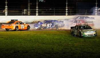 DAYTONA BEACH, FL - FEBRUARY 12:  Carl Edwards, driver of the #99 Scotts Ford, drives through the grass after crashing with Joey Logano, driver of the #20 Home Depot Toyota, Juan Pablo Montoya, driver of the #42 Target Chevrolet, and Kevin Conway, driver
