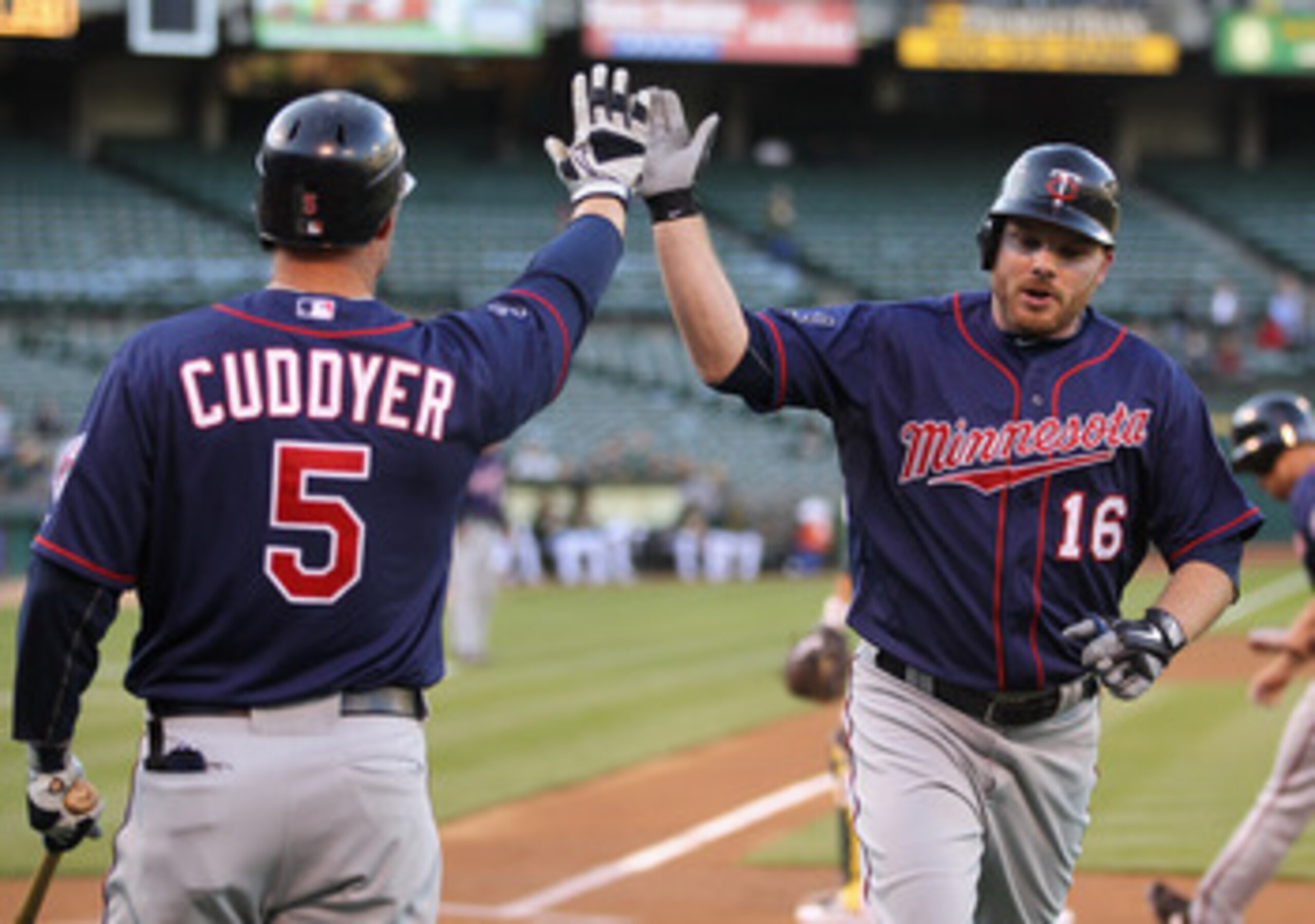OAKLAND, CA - MAY 18:  Jason Kubel #16 is congratulated by Michael Cuddyer #5 of the Minnesota Twins after he scored in the first inning against the Oakland Athletics at Oakland-Alameda County Coliseum on May 18, 2011 in Oakland, California.  (Photo by Ez