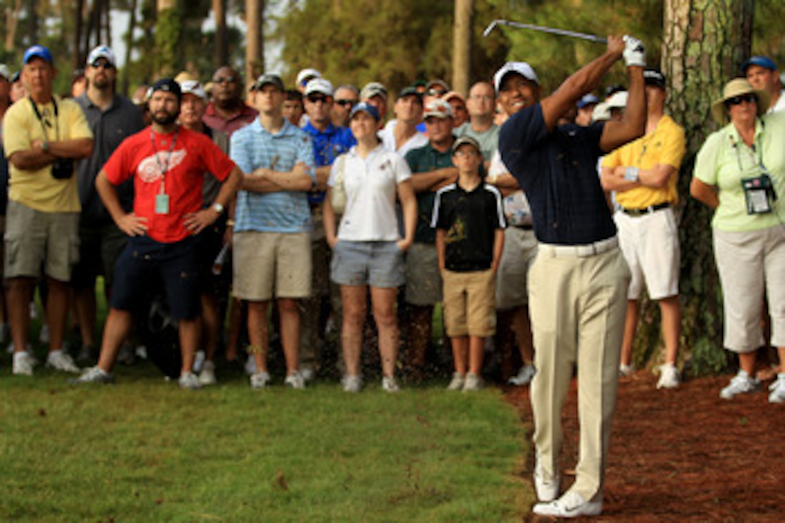 PONTE VEDRA BEACH, FL - MAY 12:  Tiger Woods hits from the rough on the first hole in front of a gallery of fans during the first round of THE PLAYERS Championship held at THE PLAYERS Stadium course at TPC Sawgrass on May 12, 2011 in Ponte Vedra Beach, Fl