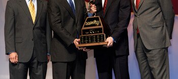 HOUSTON - APRIL 03:  Jimmer Fredette of BYU receives the 2011 Naismith Trophy Presented by AT&T from David Christopher of AT&T during the NABC Guardians of the Game Awards Program on April 3, 2011 in Houston, Texas.  Joining them on stage are Eric Oberman