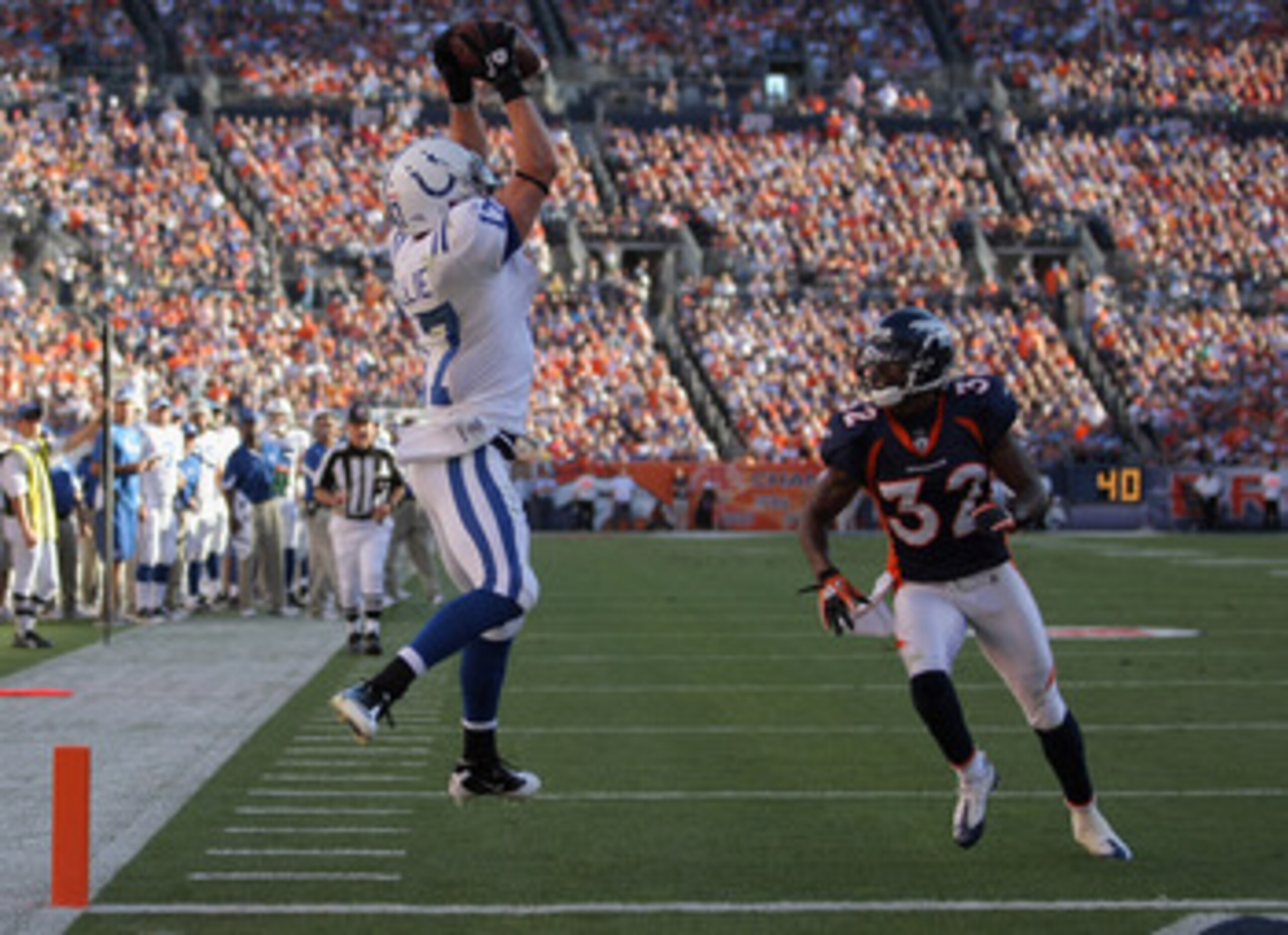 DENVER - SEPTEMBER 26:  Wide receiver Austin Collie #17 of the Indianapolis Colts makes a 23 yard touchdown reception in the fourth quarter as Perrish Cox #32 of the Denver Broncos defends at INVESCO Field at Mile High on September 26, 2010 in Denver, Col