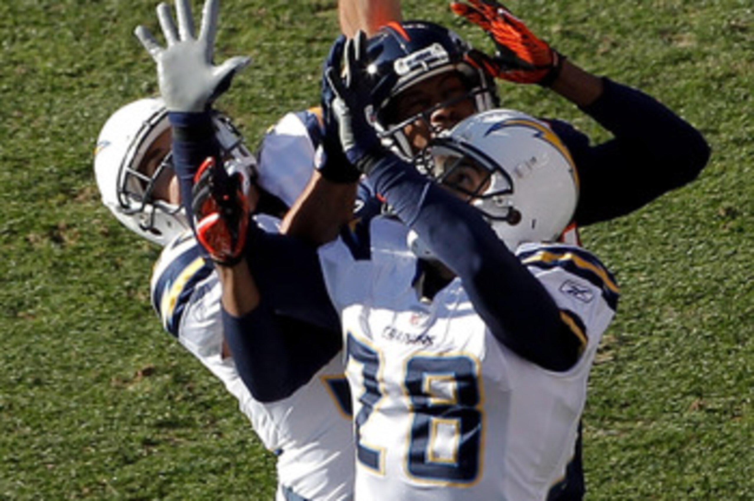 DENVER, CO - JANUARY 2:  Safety Eric Weddle #32 of the San Diego Chargers makes an interception on a pass intended for wide receiver Brandon Lloyd #84 of the Denver Broncos as they battle in the air with safety Steve Gregory #28 during the first quarter a
