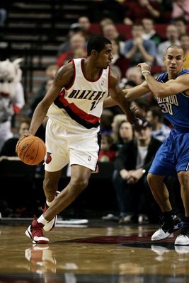 PORTLAND, OR - DECEMBER 1:  LaMarcus Aldridge #12 of the Portland Trail Blazers dribbles against Carlos Arroyo #30 of the Orlando Magic on December 1, 2006 at the Rose Garden in Portland, Oregon. The Magic won 91-89. NOTE TO USER: User expressly acknowled