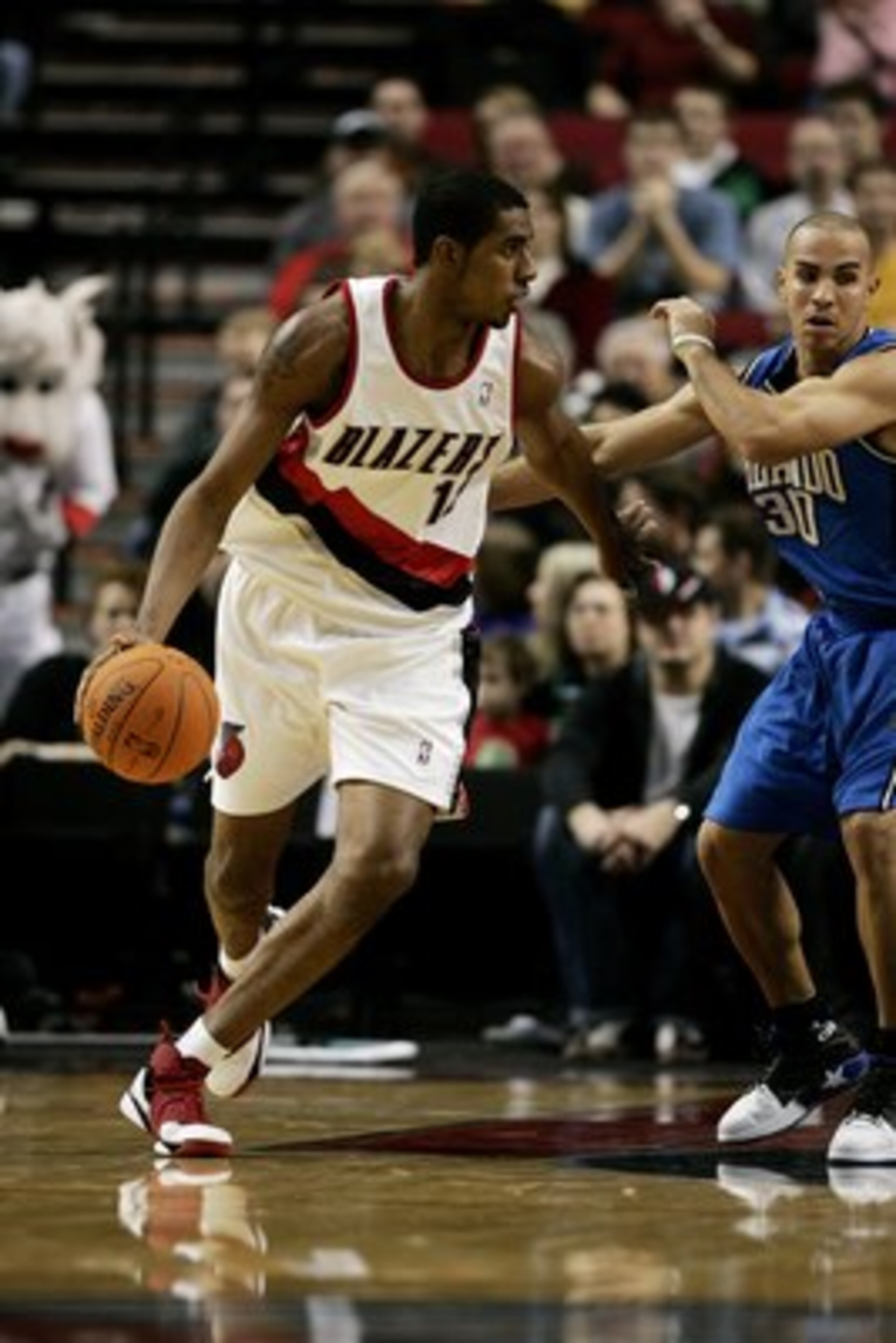 PORTLAND, OR - DECEMBER 1:  LaMarcus Aldridge #12 of the Portland Trail Blazers dribbles against Carlos Arroyo #30 of the Orlando Magic on December 1, 2006 at the Rose Garden in Portland, Oregon. The Magic won 91-89. NOTE TO USER: User expressly acknowled