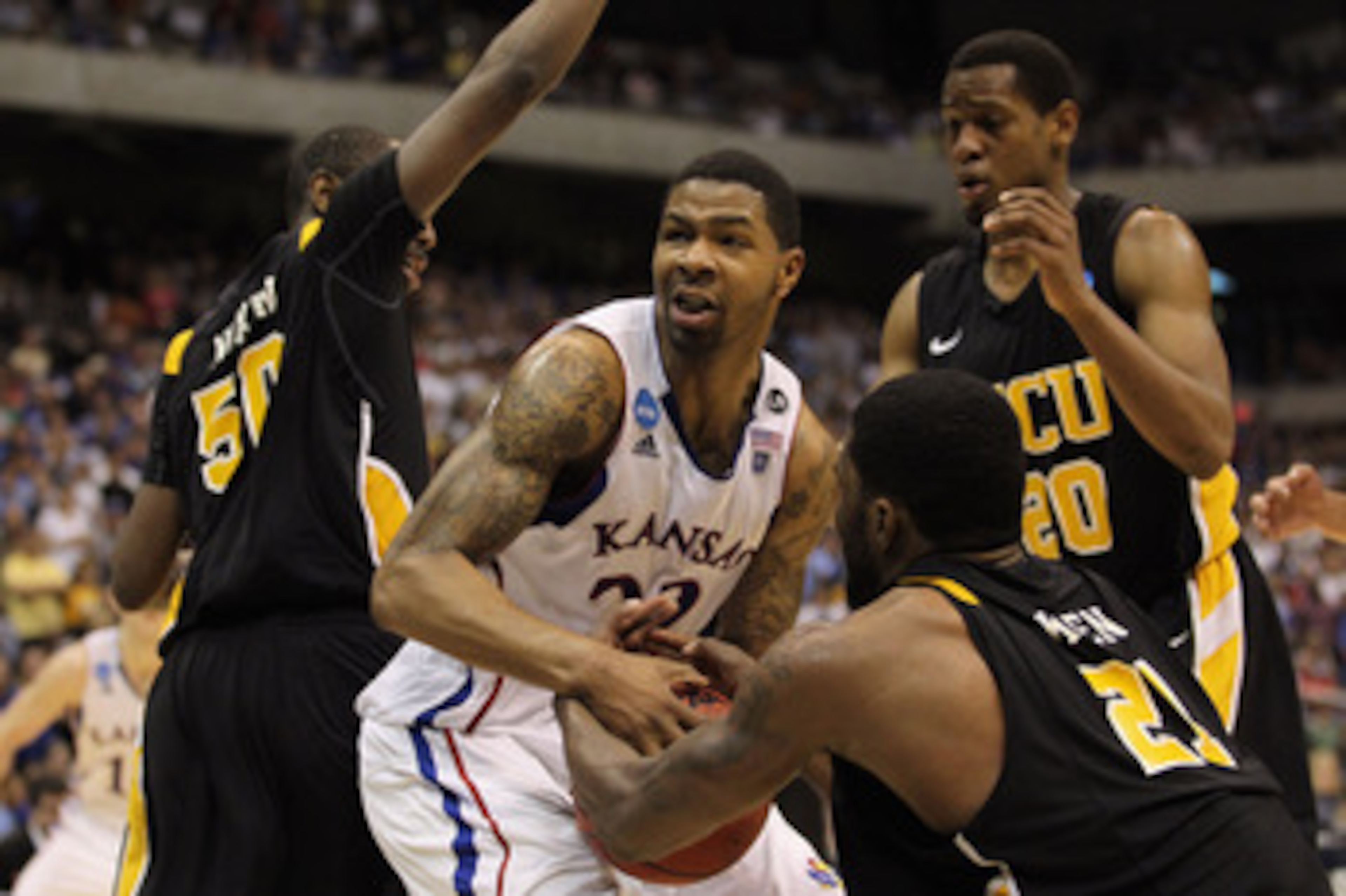 SAN ANTONIO, TX - MARCH 27:  Marcus Morris #22 of the Kansas Jayhawks handles the ball against Ed Nixon #50, Jamie Skeen #21 and Bradford Burgess #20 of the Virginia Commonwealth Rams during the southwest regional final of the 2011 NCAA men's basketball t