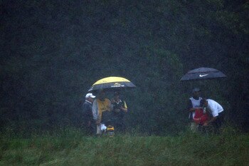 FARMINGDALE, NY - JUNE 20:  Camilo Villegas of Colombia and Stewart Cink stand with their caddies under umbrellas in the rain during the third round of the 109th U.S. Open on the Black Course at Bethpage State Park on June 20, 2009 in Farmingdale, New Yor