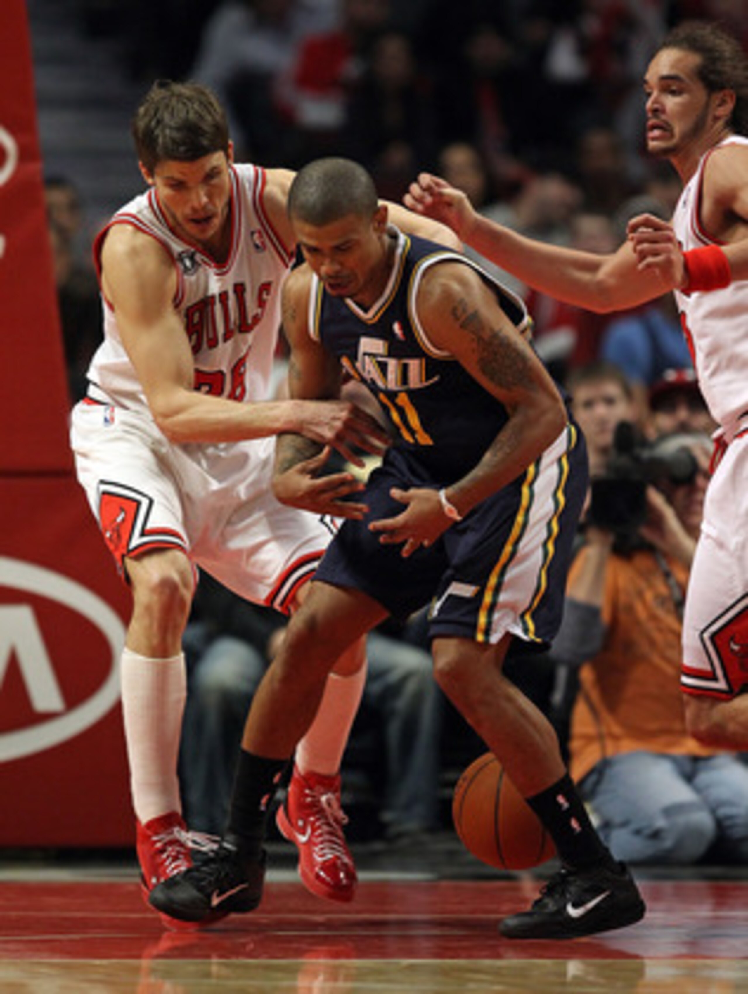 CHICAGO, IL - MARCH 12: Kyle Korver #26 of the Chicago Bulls knocks the ball away from Earl Watson #11 of the Utah Jazz as Joakim Noah #13 defends at the United Center on March 12, 2011 in Chicago, Illinois. The Bulls defeated the Jazz 118-100. NOTE TO US