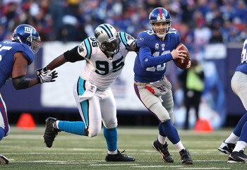 EAST RUTHERFORD, NJ - DECEMBER 27:  Eli Manning #10 of the New York Giants is chased down Charles Johnson #95 of the Carolina Panthers at Giants Stadium on December 27, 2009 in East Rutherford, New Jersey.  (Photo by Nick Laham/Getty Images)
