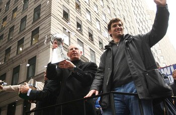 NEW YORK - FEBRUARY 05:  New York Giants coach Tom Coughlin (L) and quarterback Eli Manning wave to fans during the New York Giants Superbowl XLII victory parade February 5, 2008 in New York City.  (Photo by Chris McGrath/Getty Images)